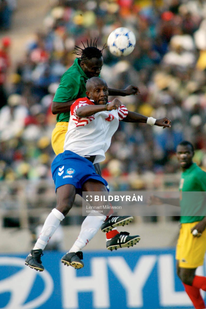  James Debbah, Liberia trycks i ryggen av en Mali-spelare.