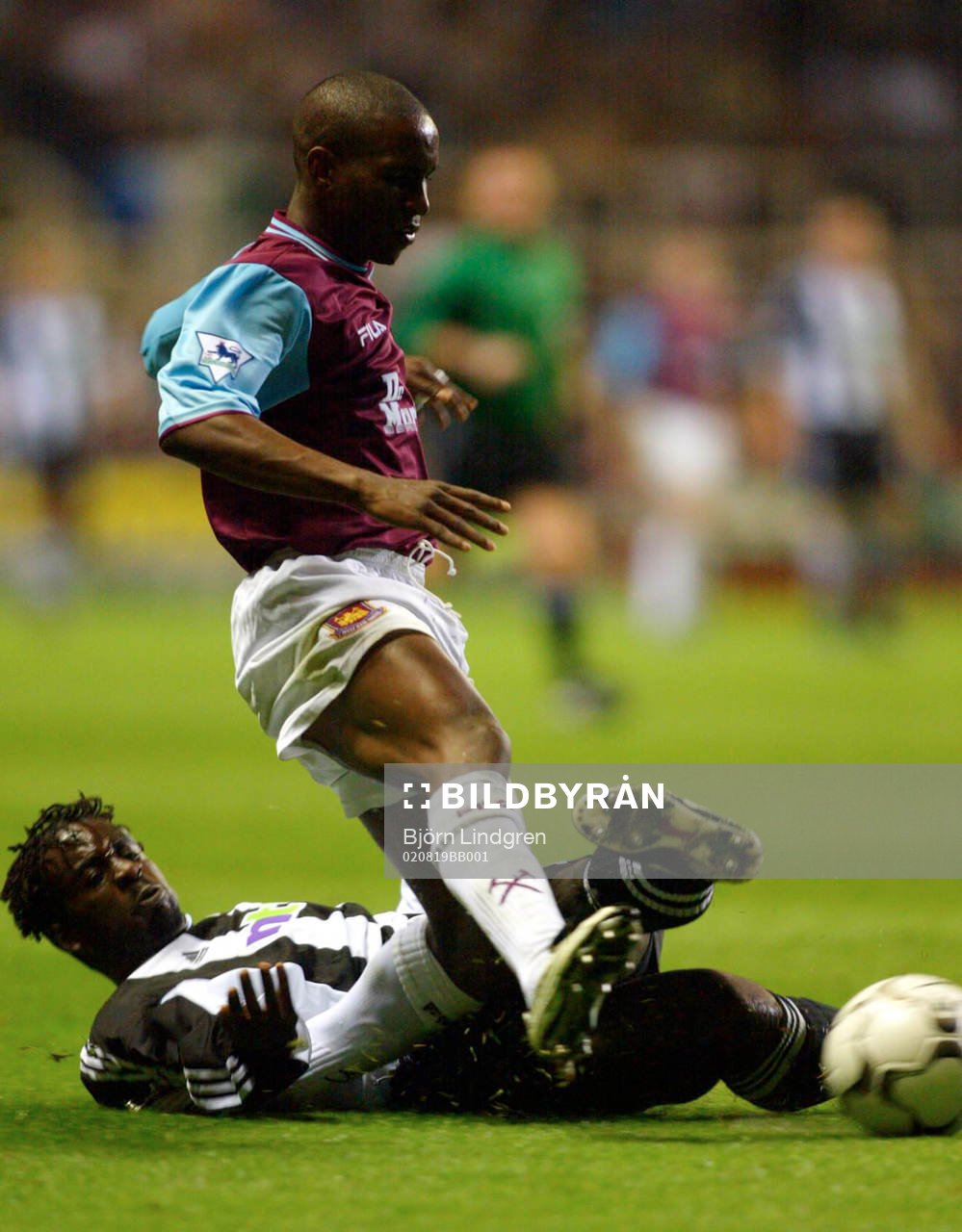 Fotboll, Premier League (Engelsk Liga), Newcastle - West Ham: Olivier Bernard, Newcastle gör en perfekt glidtackling på Trevor Sinclair, West Ham