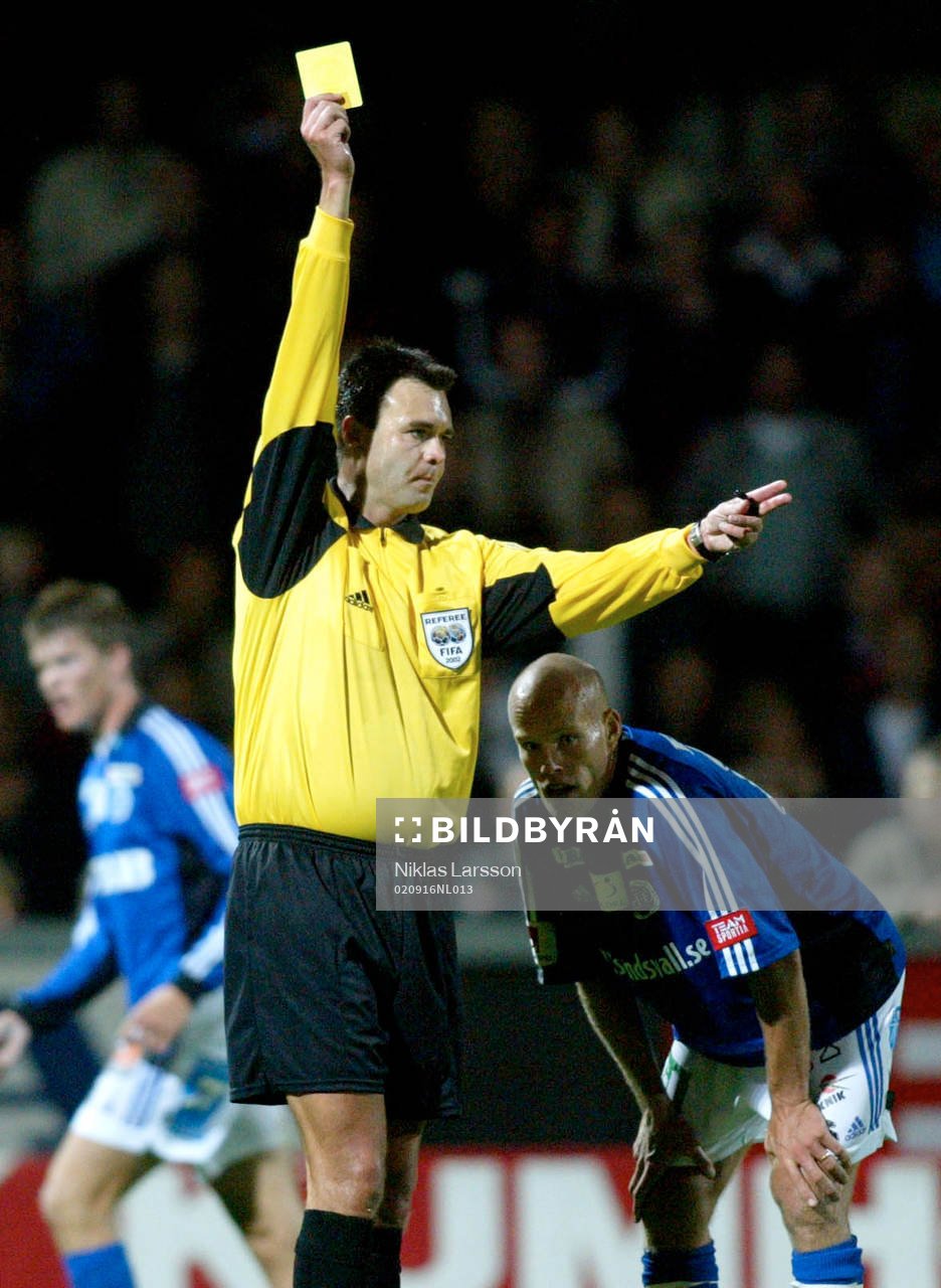 Martin Ingvarsson, domare delar ut en varning