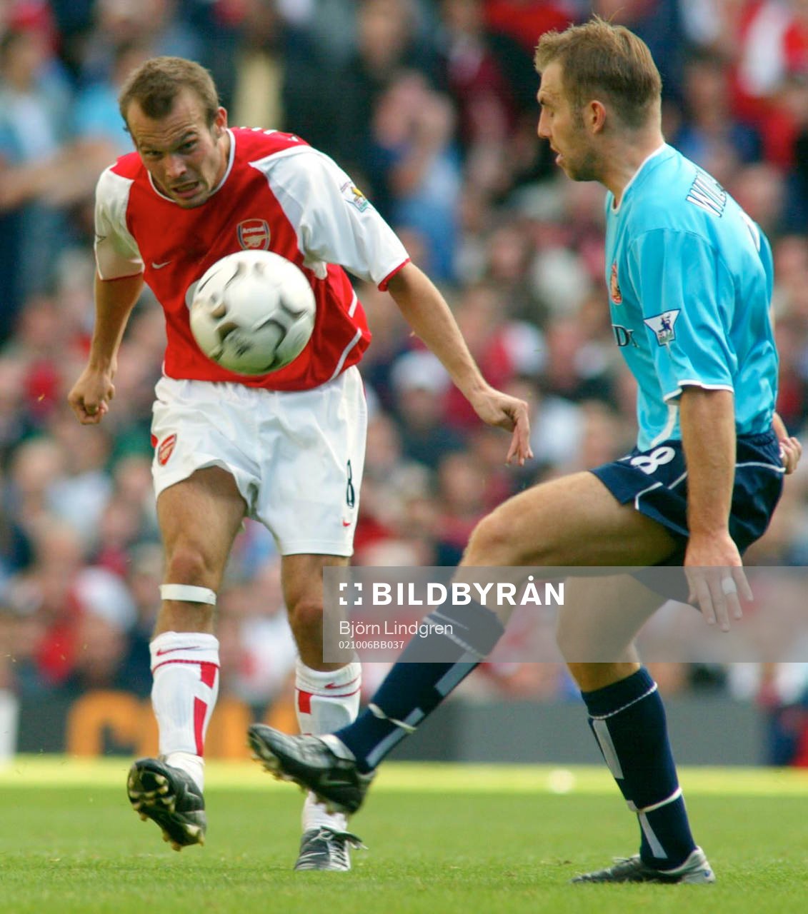 Fredrik Ljungberg slår en passning förbi Darren Williams