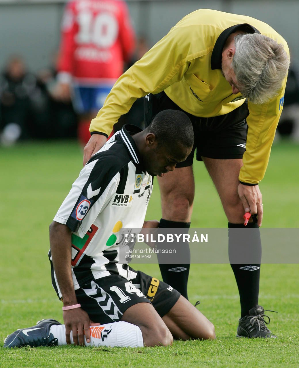 Domaren Peter Fröjdfeldt tittar till skadade Kevin Amuneke