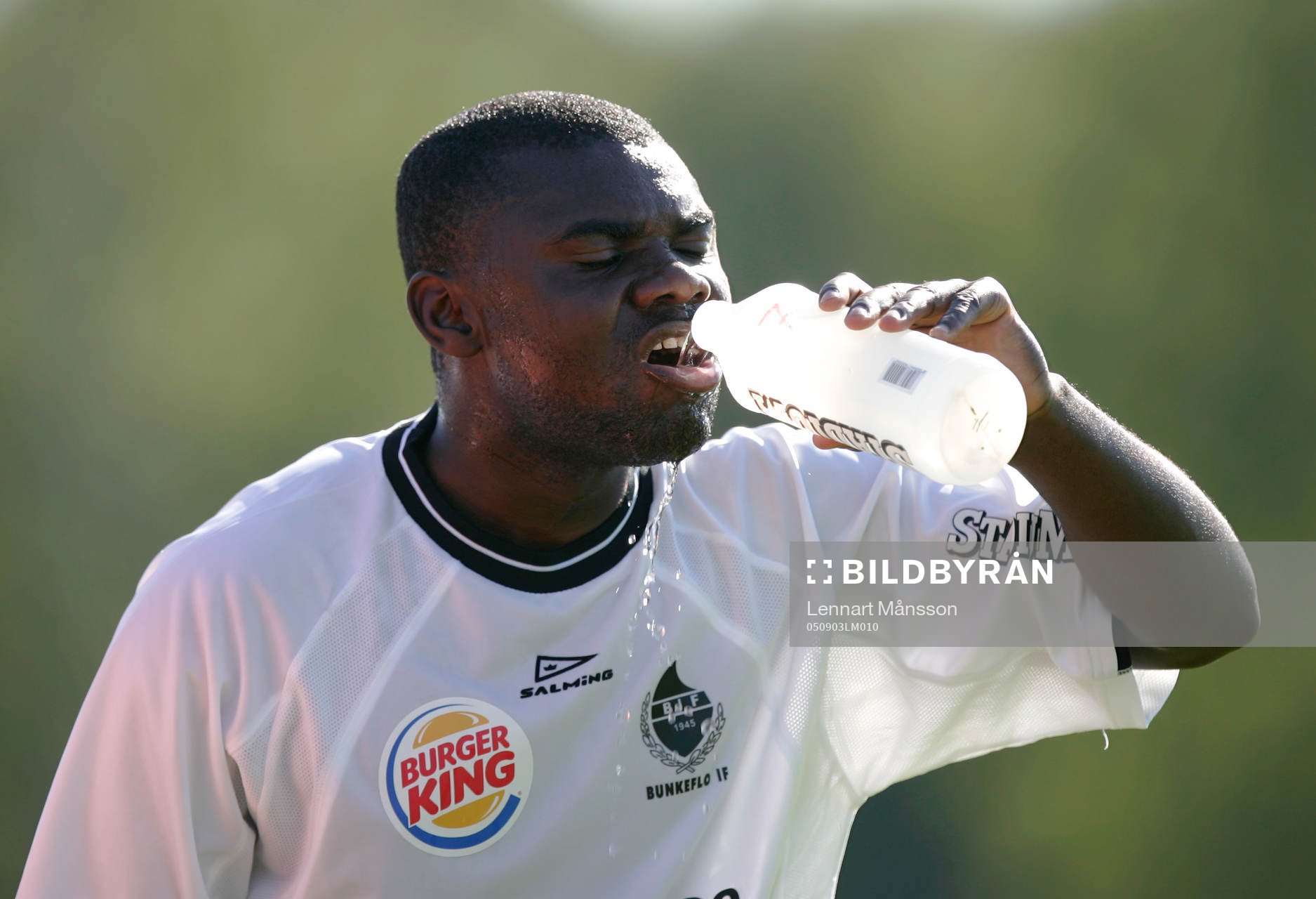 Mike Owusu dricker. Vattenflaska