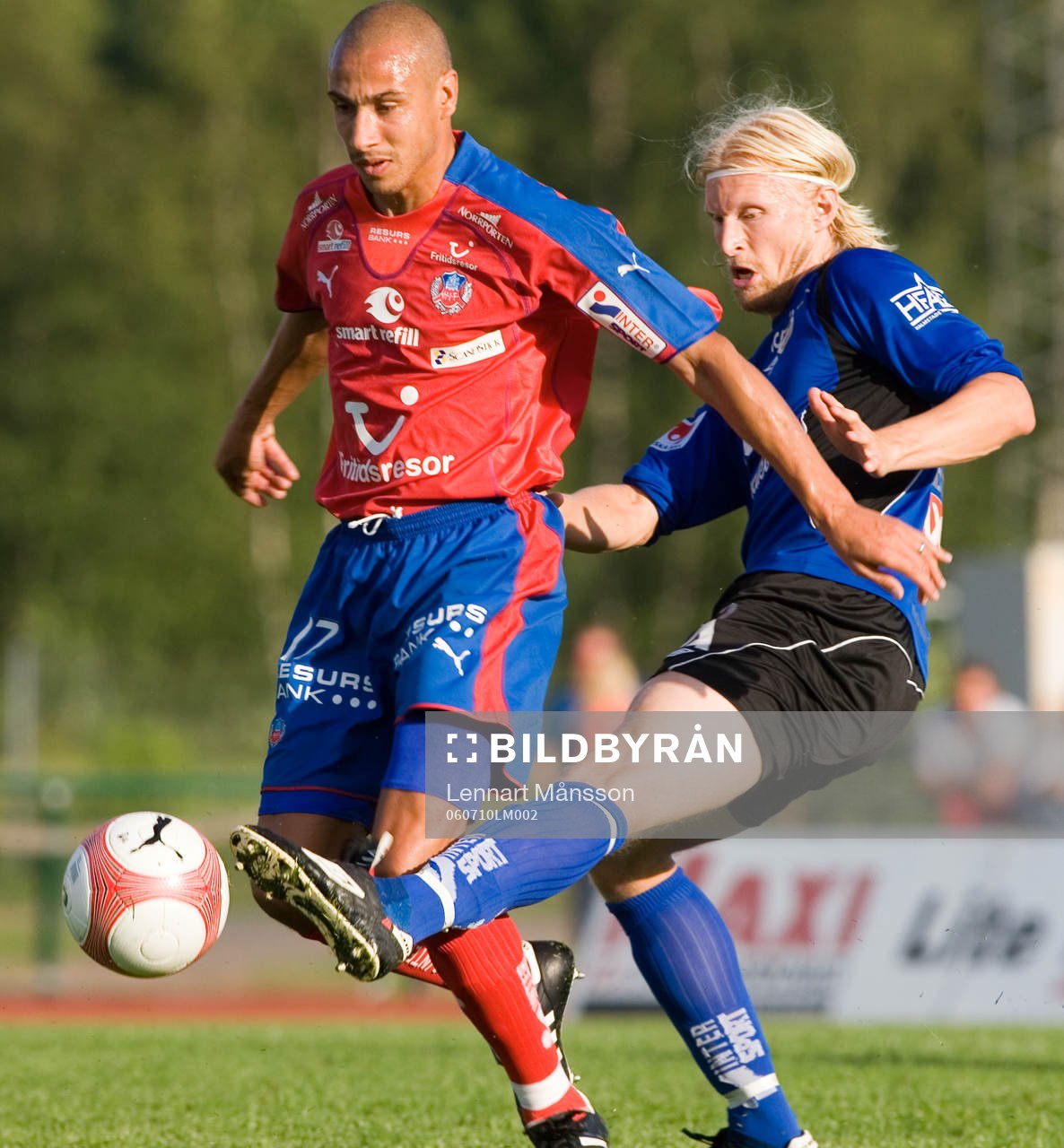 Per Johansson sparkar undan bollen framför Henrik Larsson
