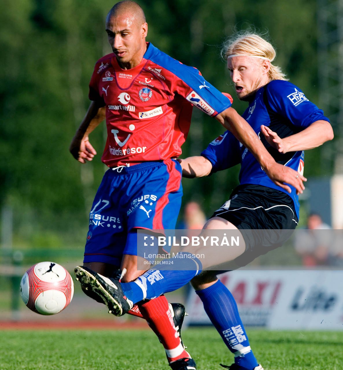 Per Johansson sparkar undan bollen framför Henrik Henke