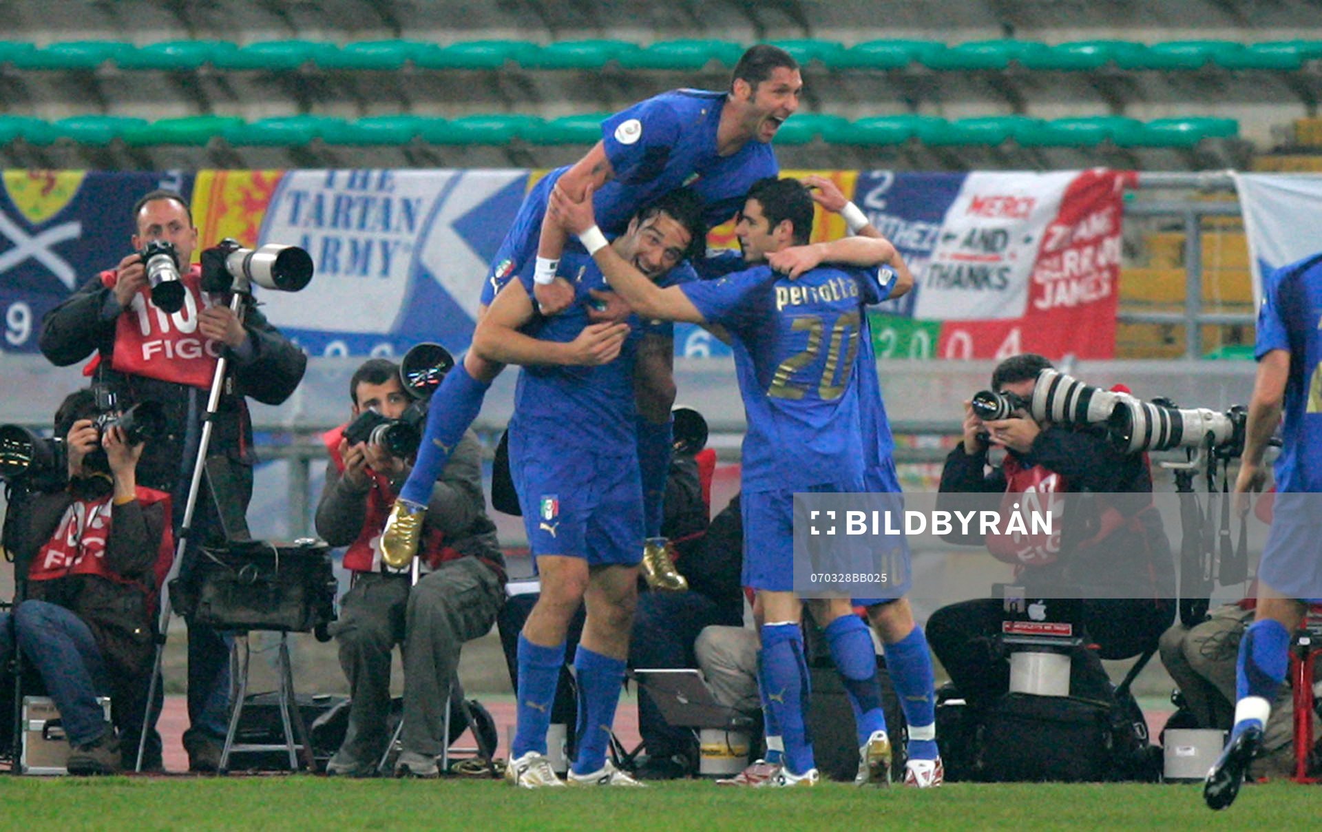 Luca Toni gratuleras av  Marco Materazzi och Simone