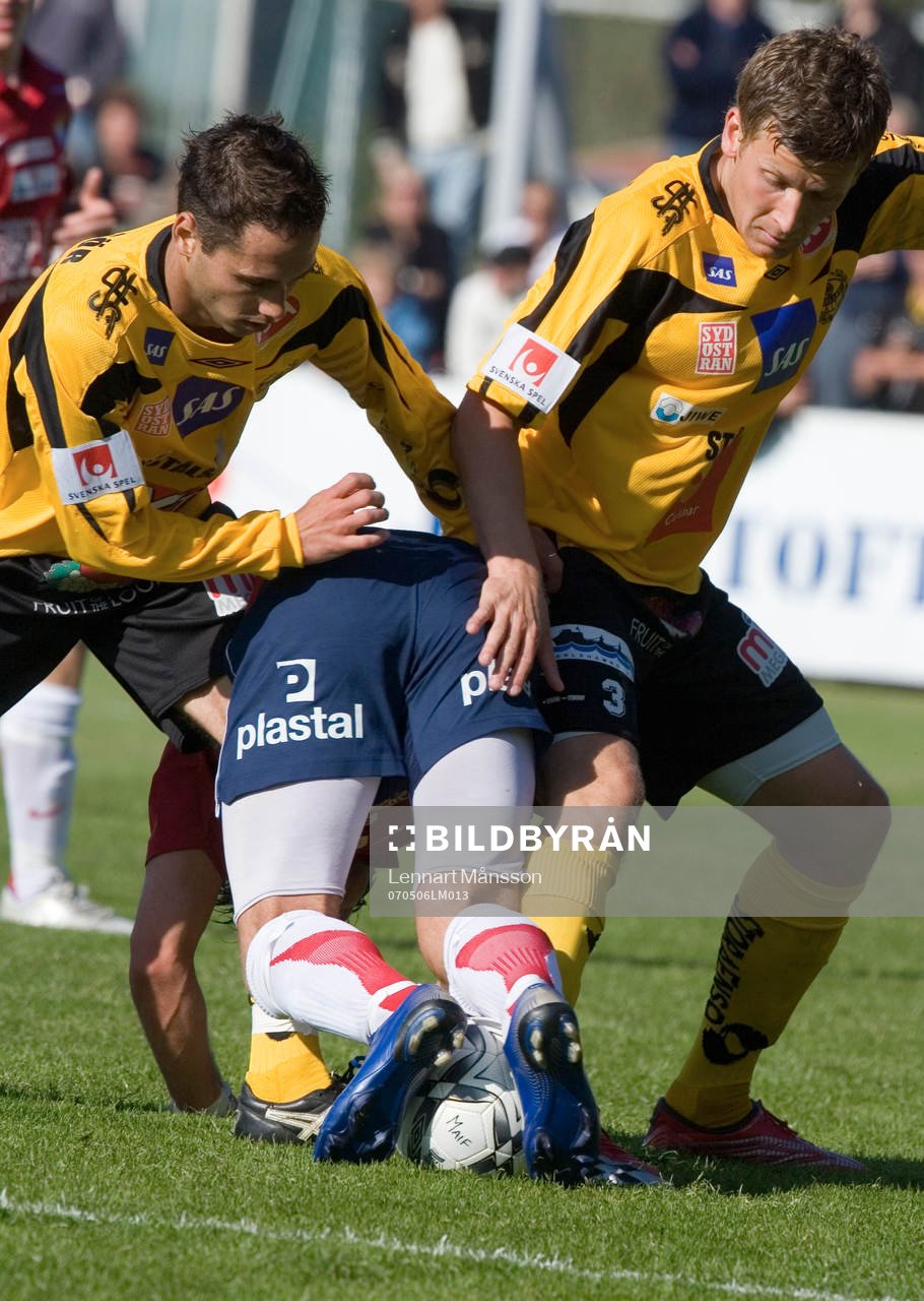  Två Mjällby-spelare tar en Örgryte-spelare bakifrån.
