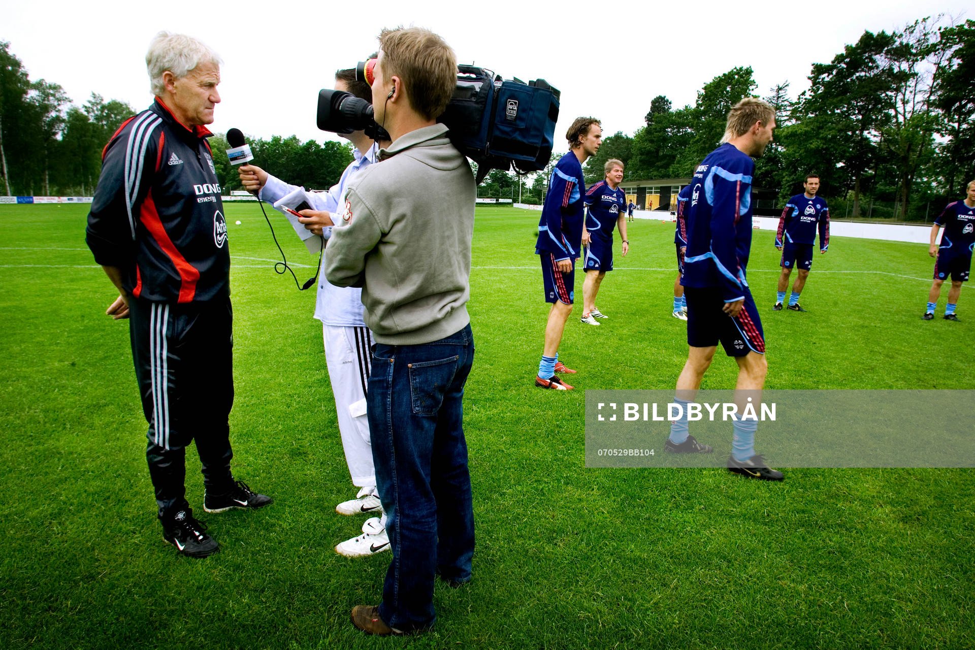  Morten Olsen, förbundskapten blir intervjuad av Media mitt på träningsplanen innan träningen börjar. 