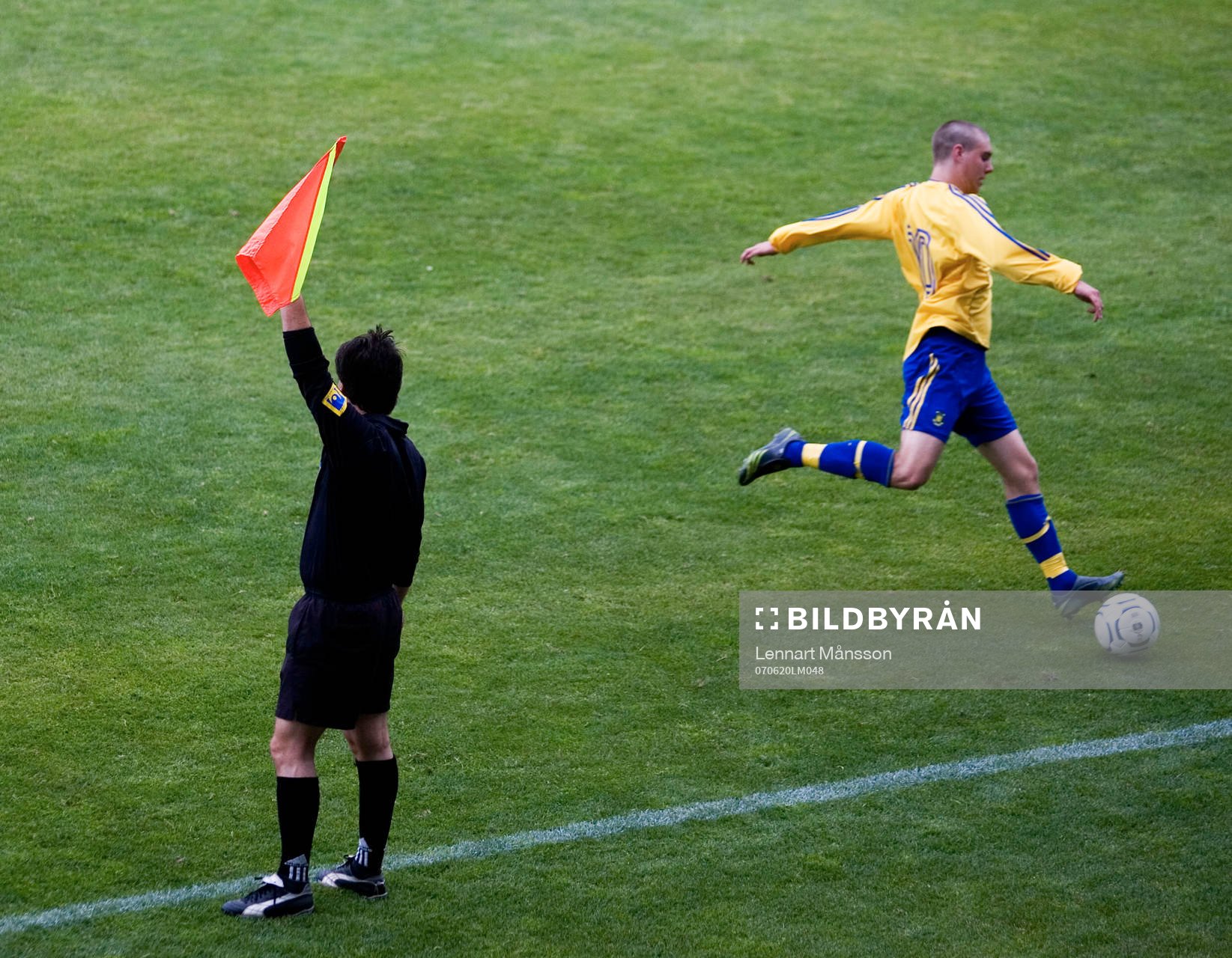 Offside, assisterande domare vinkar offside på en spelare.