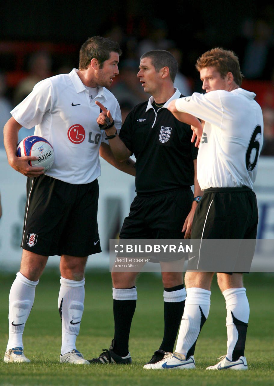  Franck Queudrue och Steven Davis, Fulham pratar med Andy D'Urso, domare
