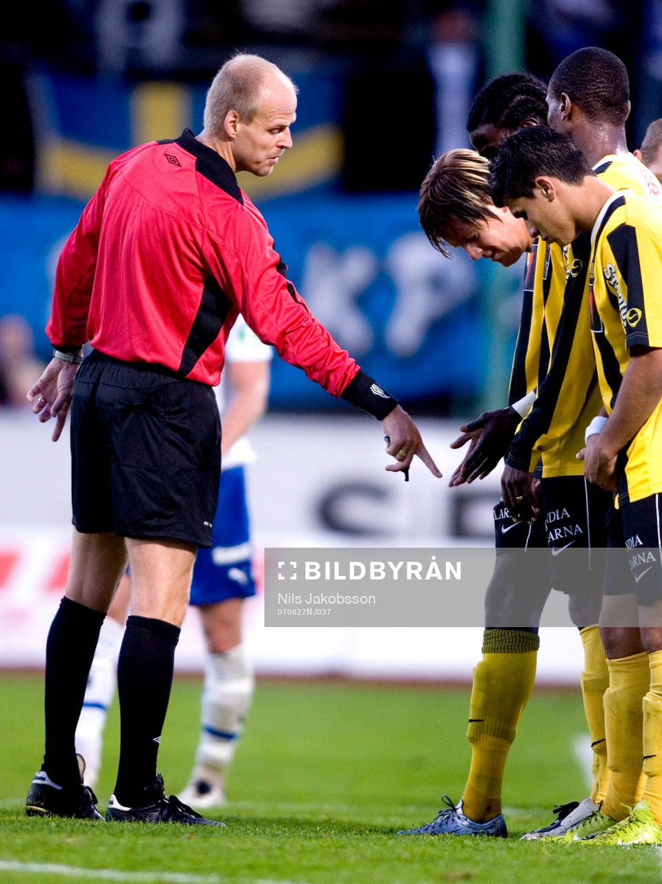 Patrik Berglund, domare, visar muren vart