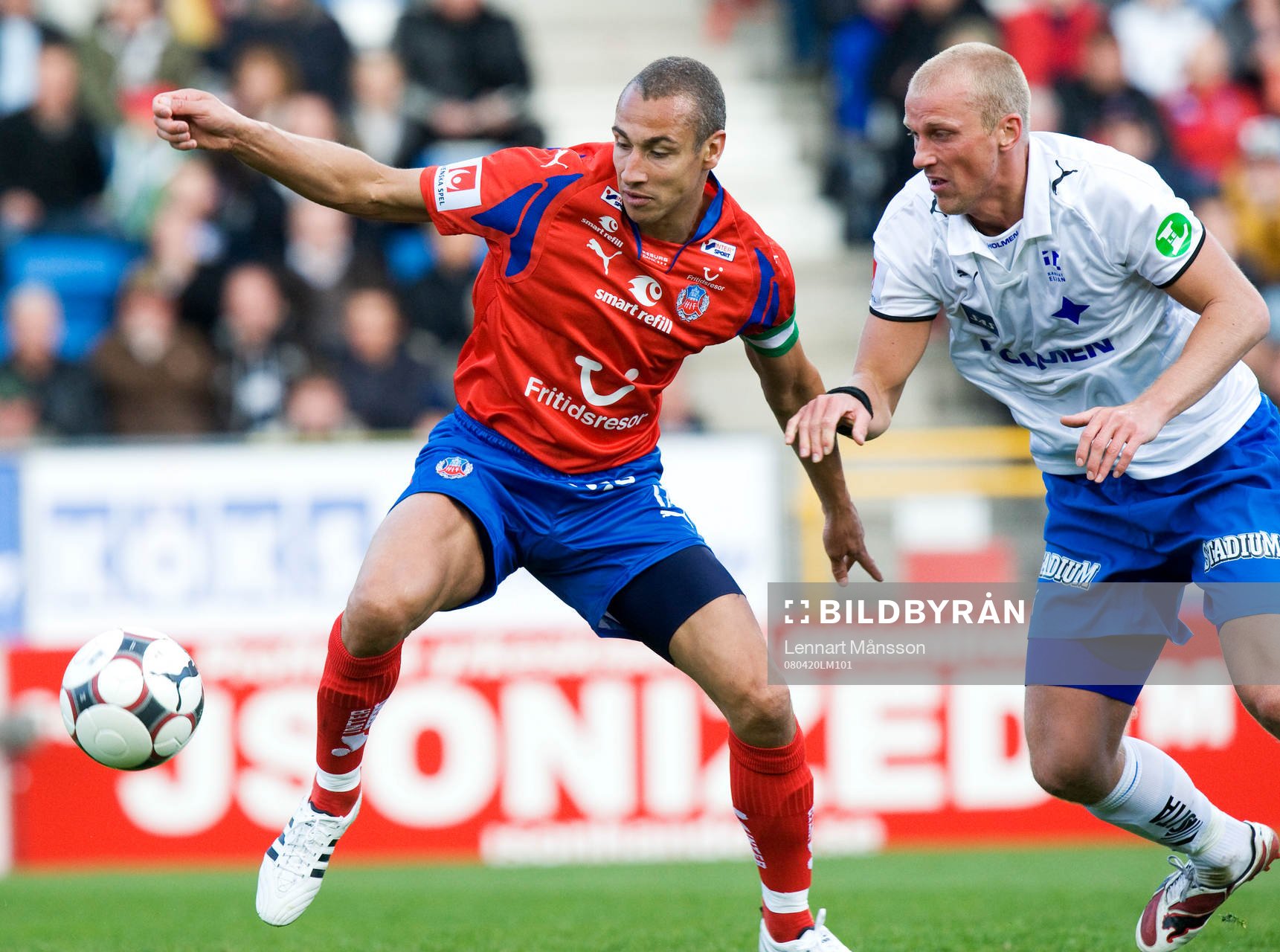 Henrik Larsson tar ner bollen och håller undan Thomas