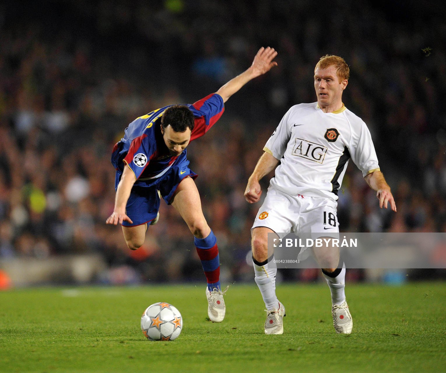 Andres Iniesta (L) and Manchester United's Paul Scholes