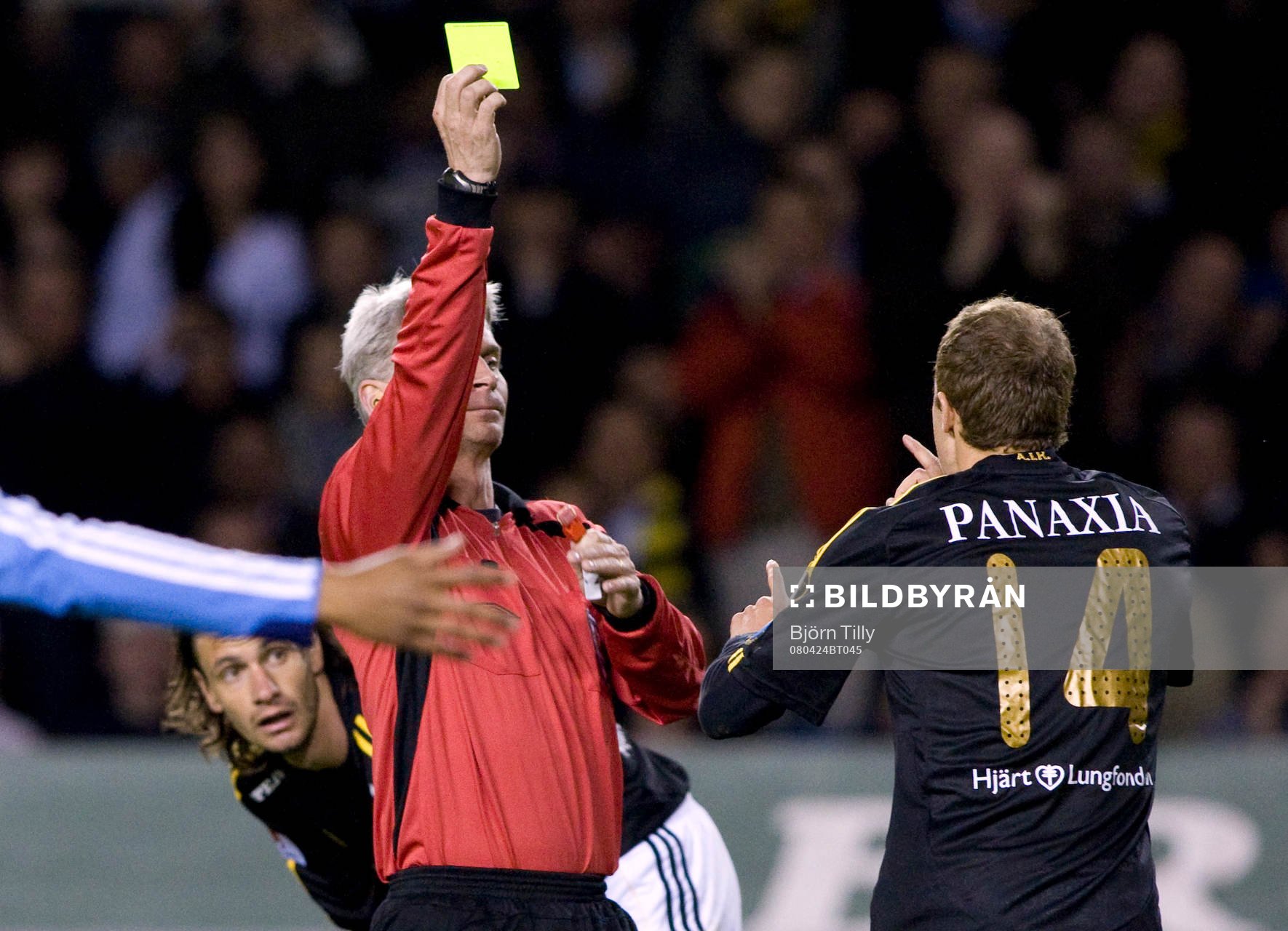 Peter Fröjdfeldt, domare ger Kenny Pavey, AIK gult kort,