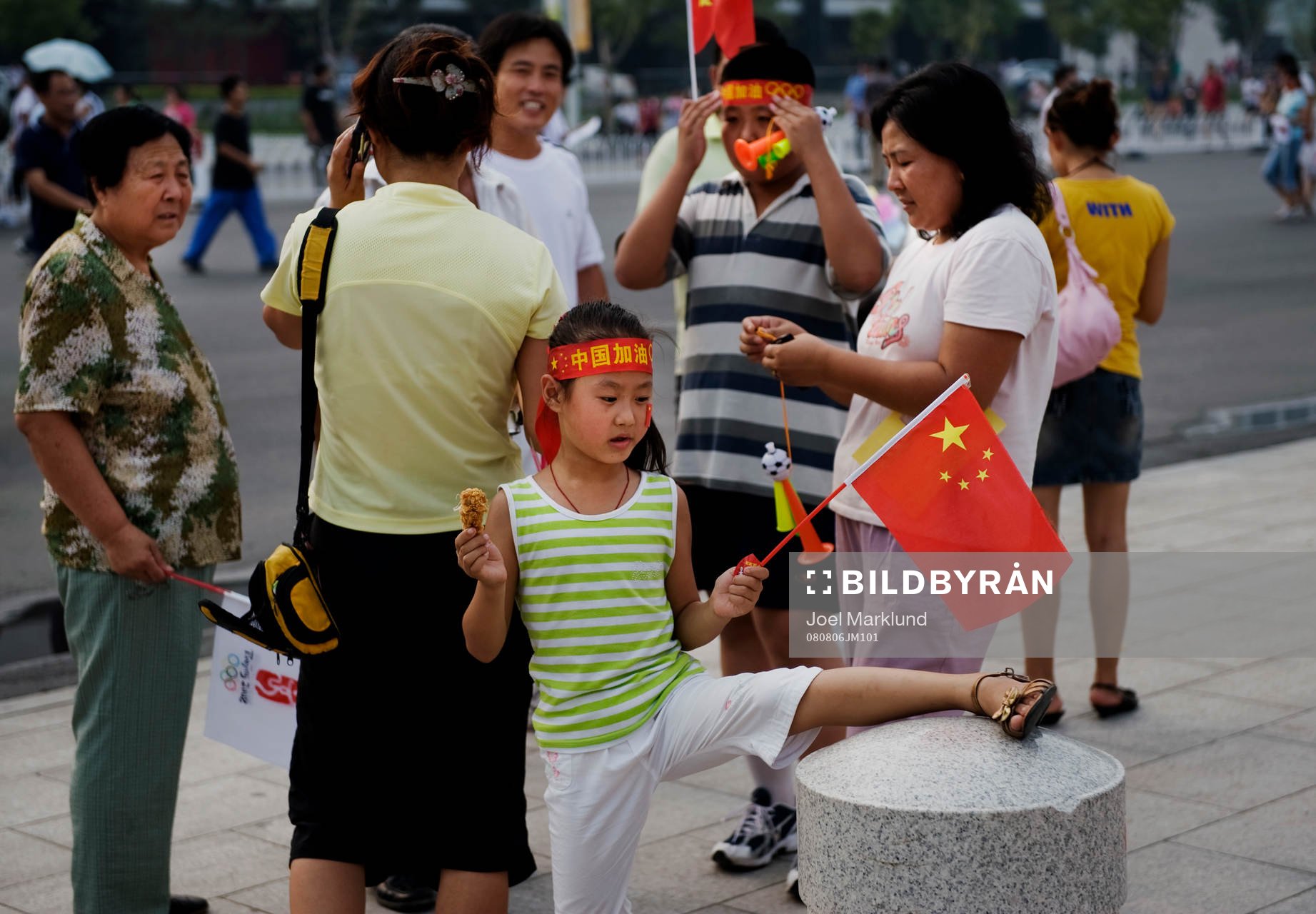 En flicka med familj som väntar utanför Tianjin Olympic
