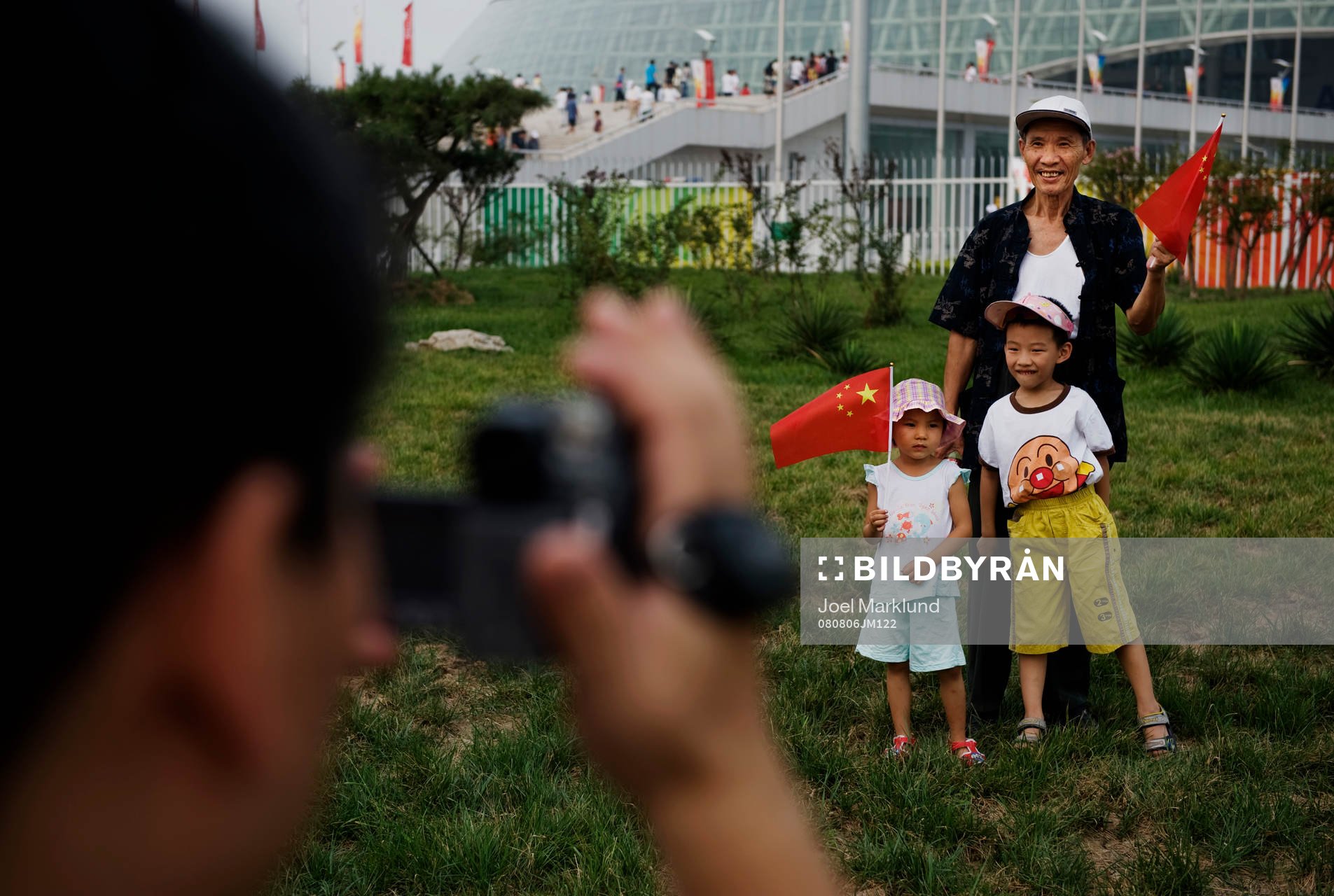 Familjer tar bilder utanför Tianjin Olympic Center Stadium