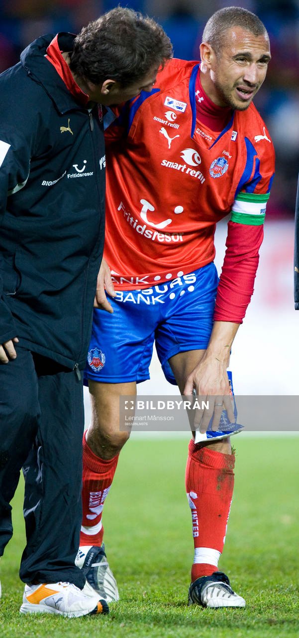 Henrik Larsson skadad, trycker en kylpåse mot knäet. Skada