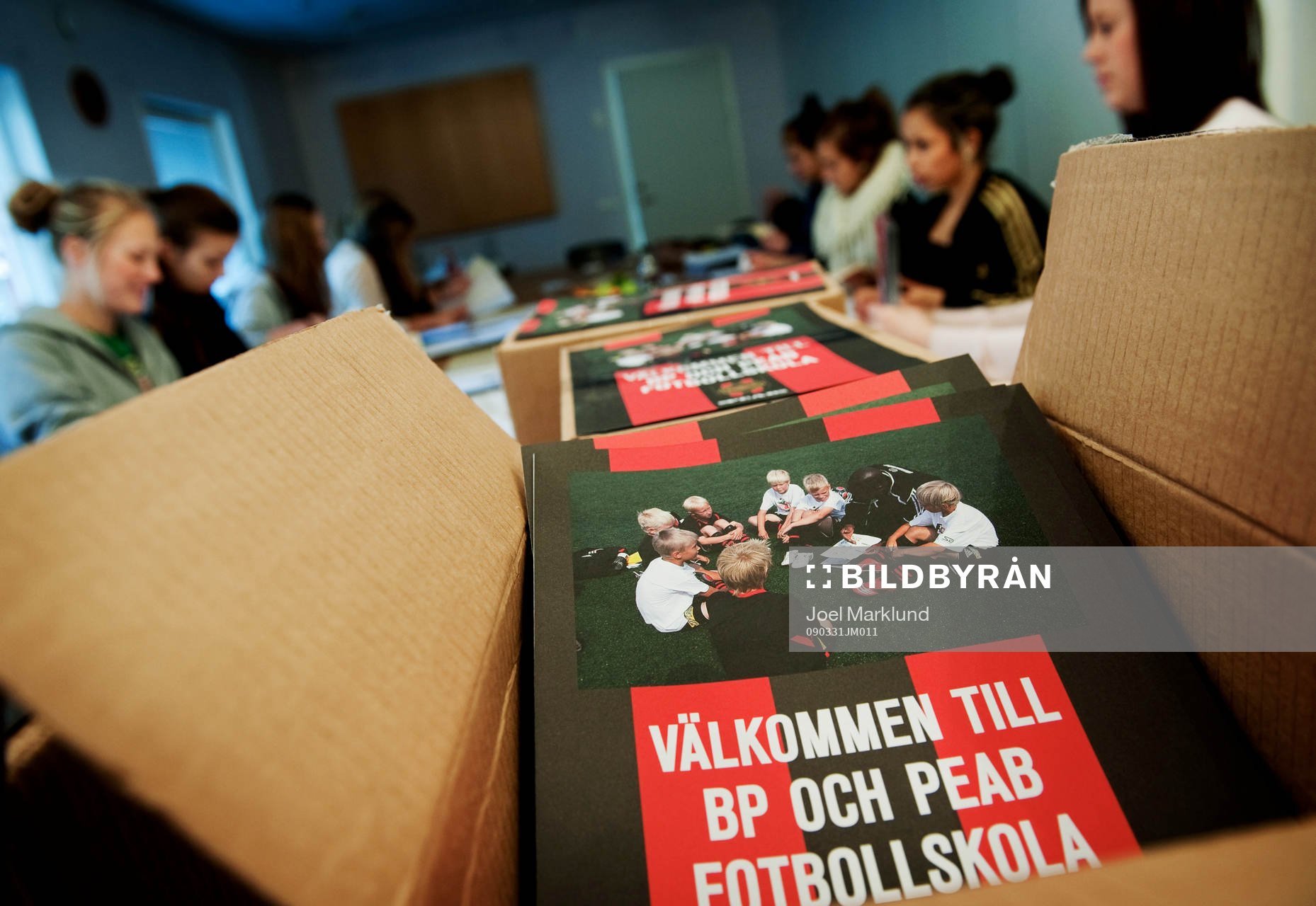 Inne på kansliet sitter ungdomar och viker annonsblad som