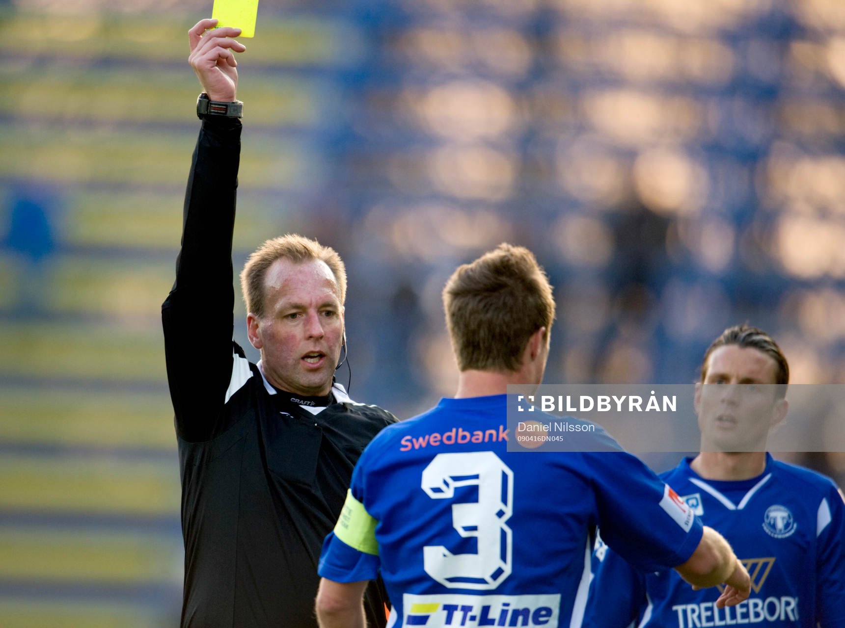 Håkan Jonasson, domare ger gult kort. Varning