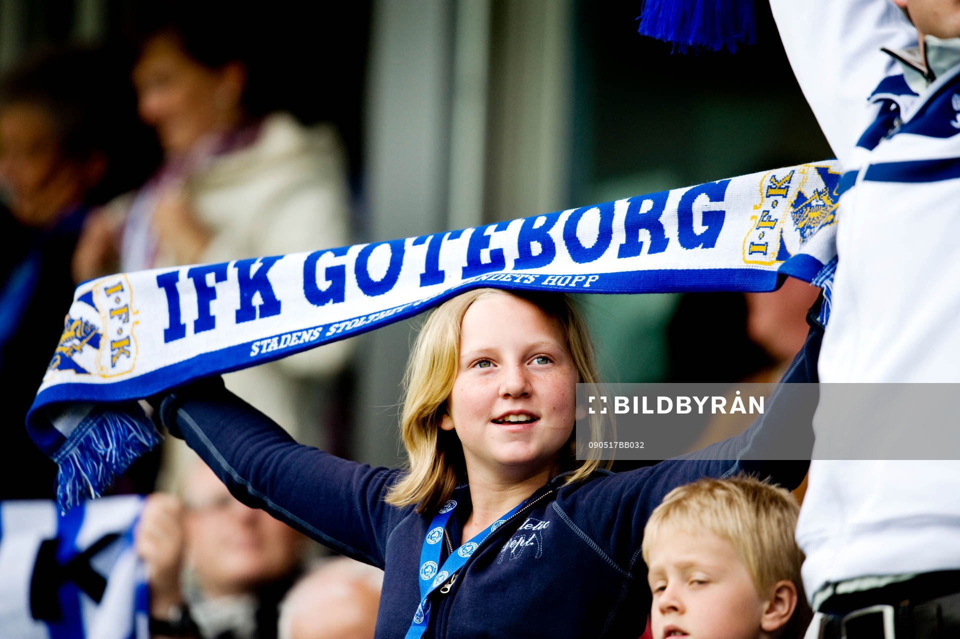 Supporter med halsduk, fans, läktare, publik, barn, flicka