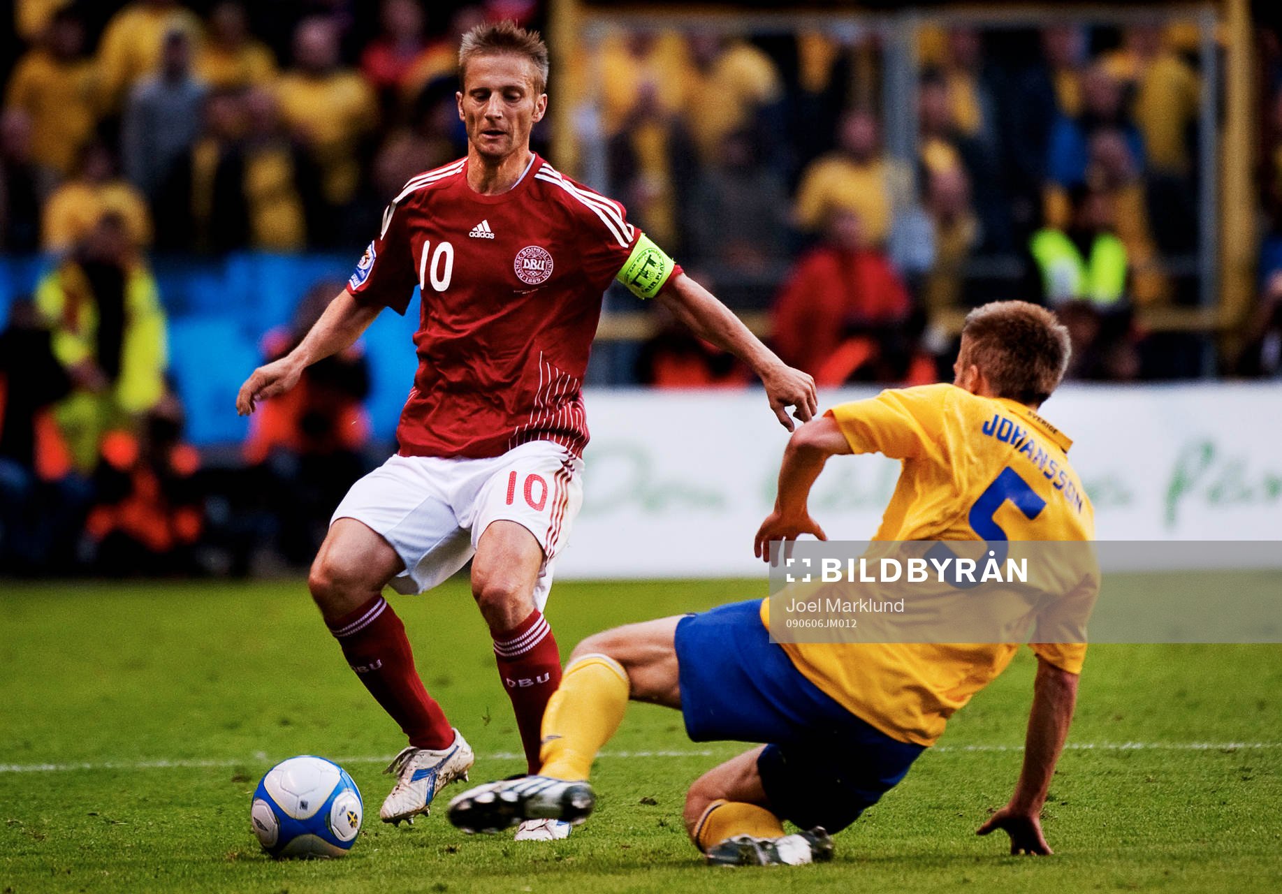  Adam Johansson, Sverige, stoppar en boll framför Martin Jörgensen, Danmark.