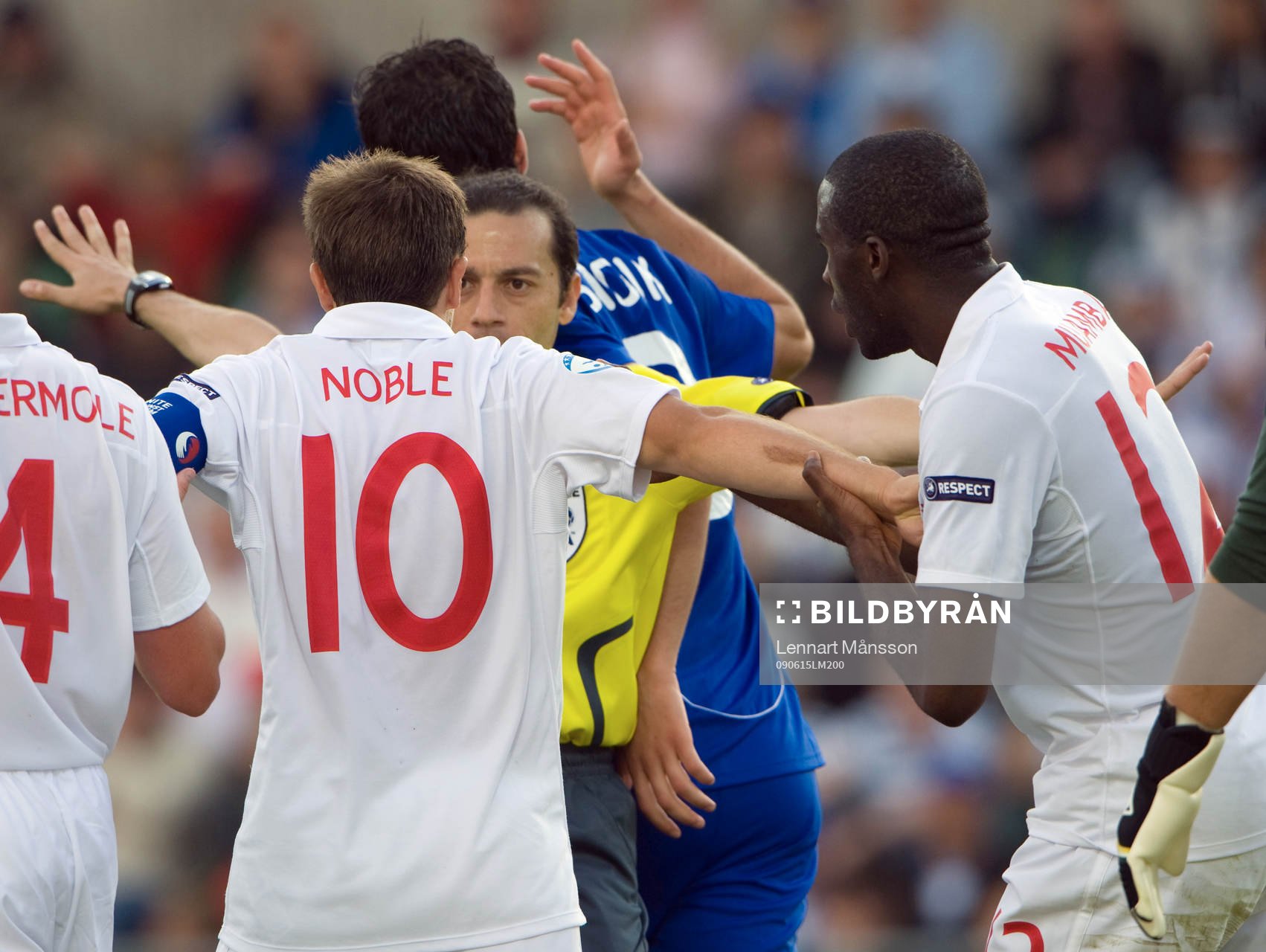 Cüneyt Cakir, domare, i diskussion med Mark Noble, England