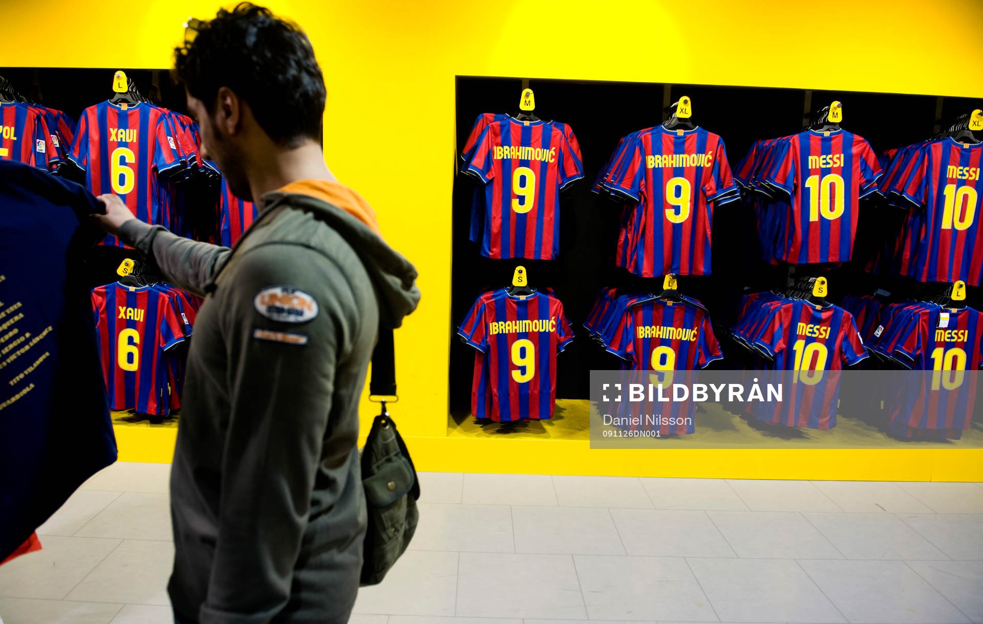 En man tittar på tröjor i Barcelona-shopen