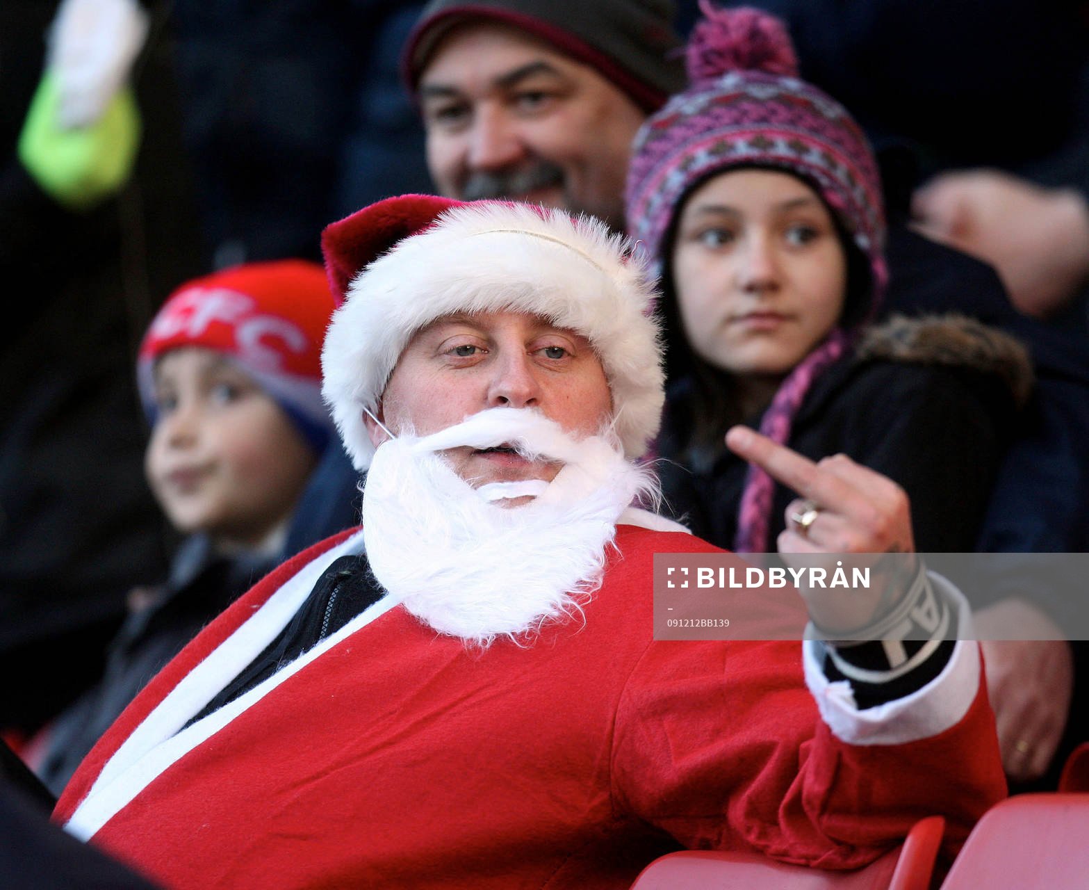 En bråkig supporter utklädd till jultomte gör fula tecken