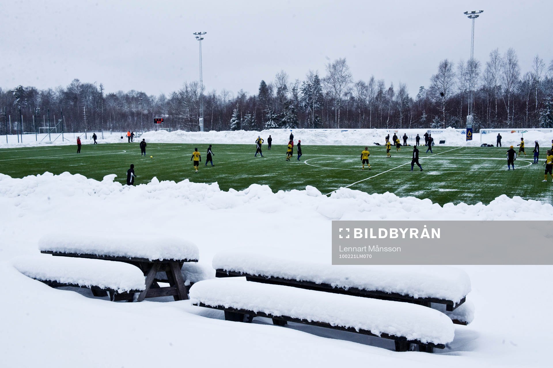 Konstgräs, snö på plan, snödrivor. Snötäckta bänkar,