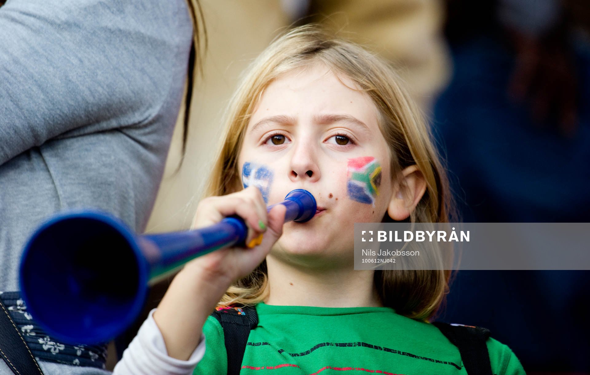 En flicka blåser i vuvuzela