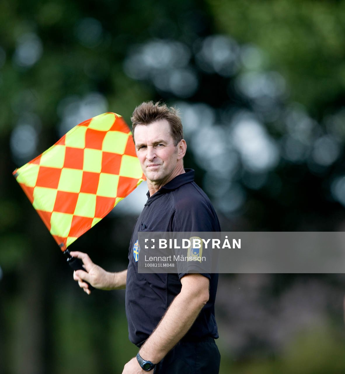 Assisterande domare vinkar med sin flagga