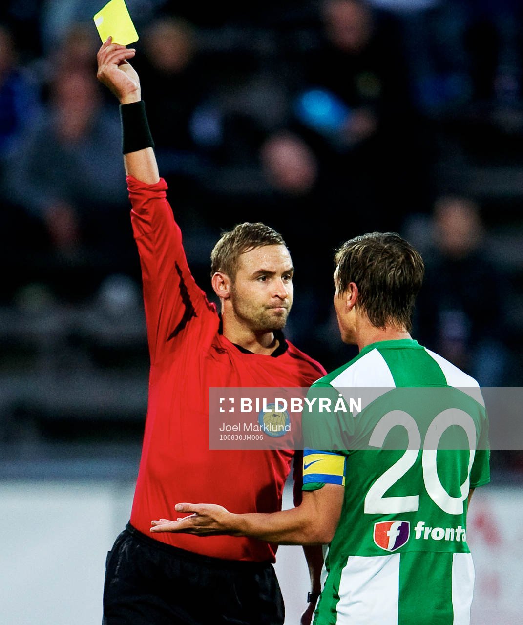 Jim Petersson, domare, delar ut ett gult kort till Filip