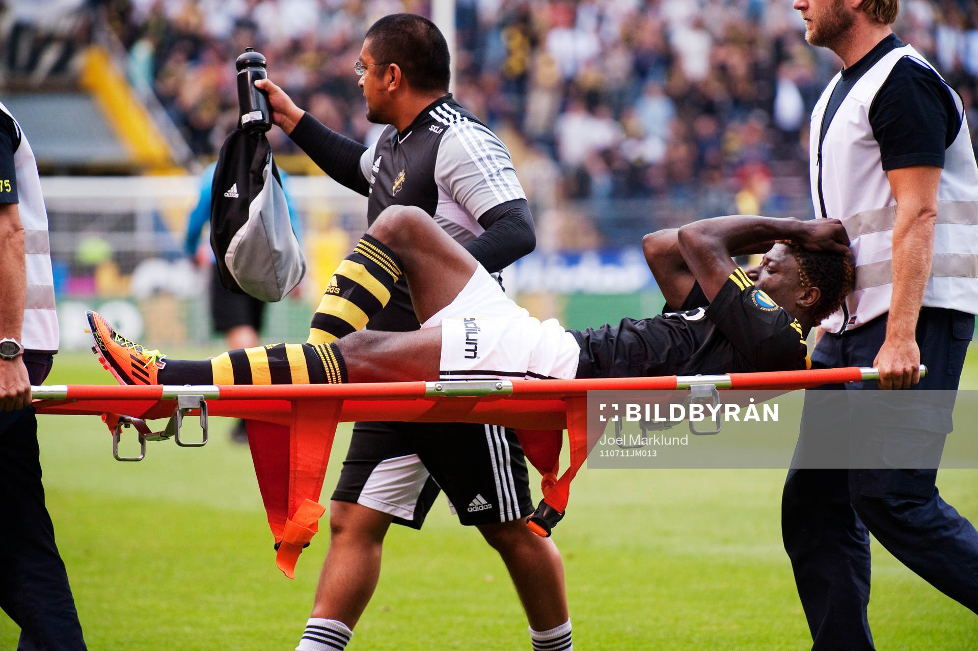 Mohamed Bangura, AIK, bärs ut på bår. Skada