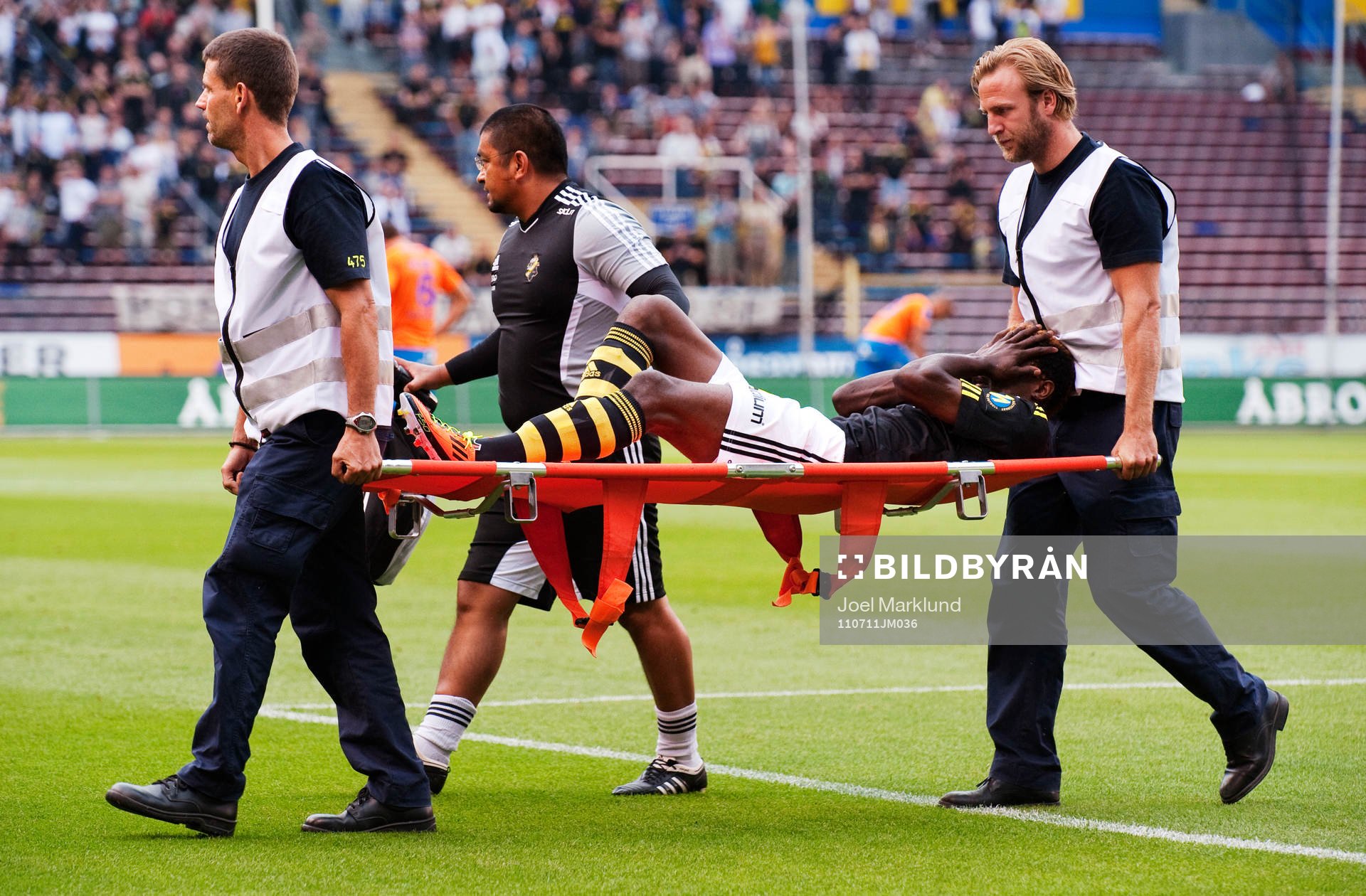 Mohamed Bangura, AIK, bärs ut på bår. Skada