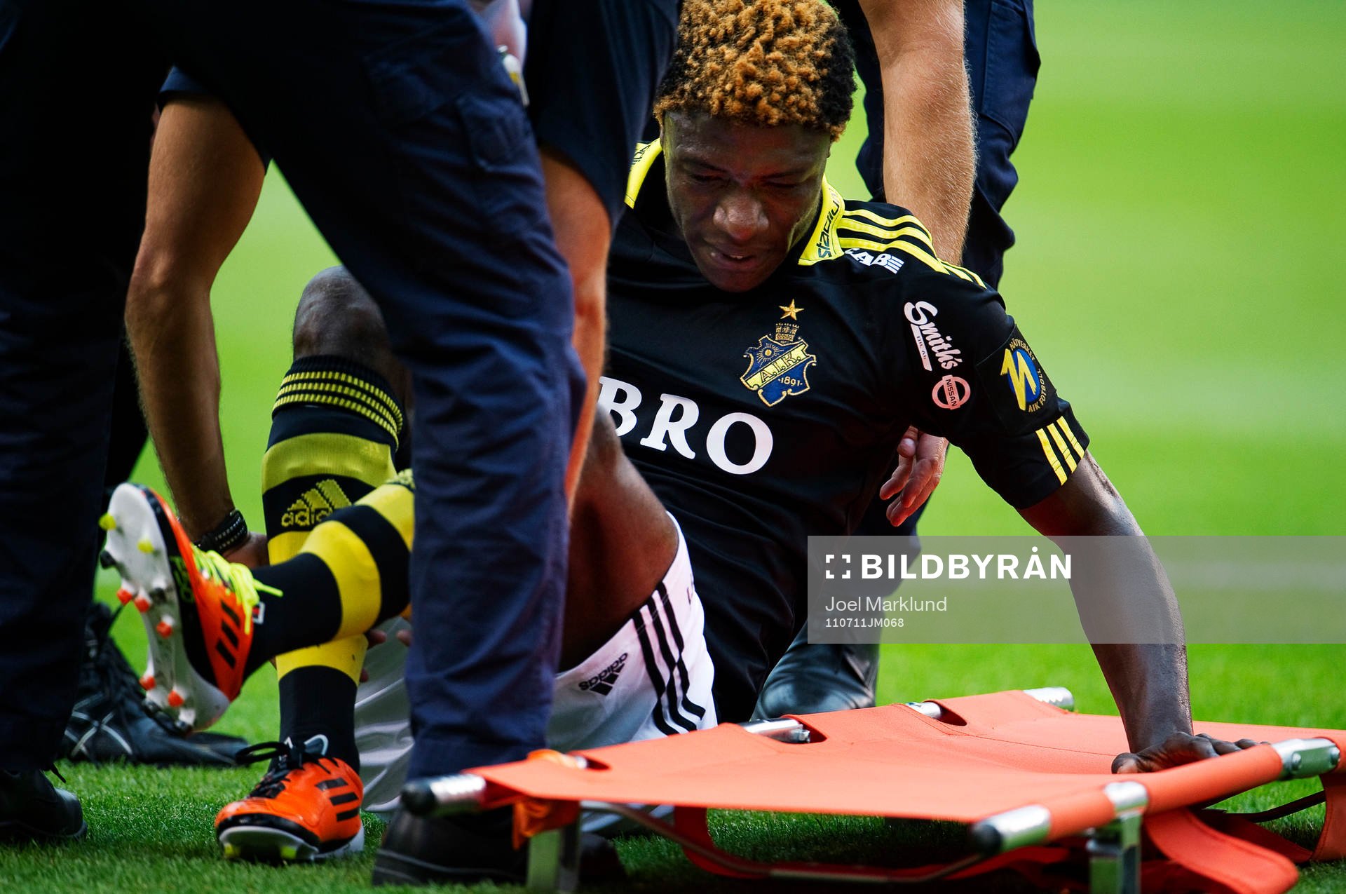 Mohamed Bangura, AIK, förs ut skadad på bår. Skada