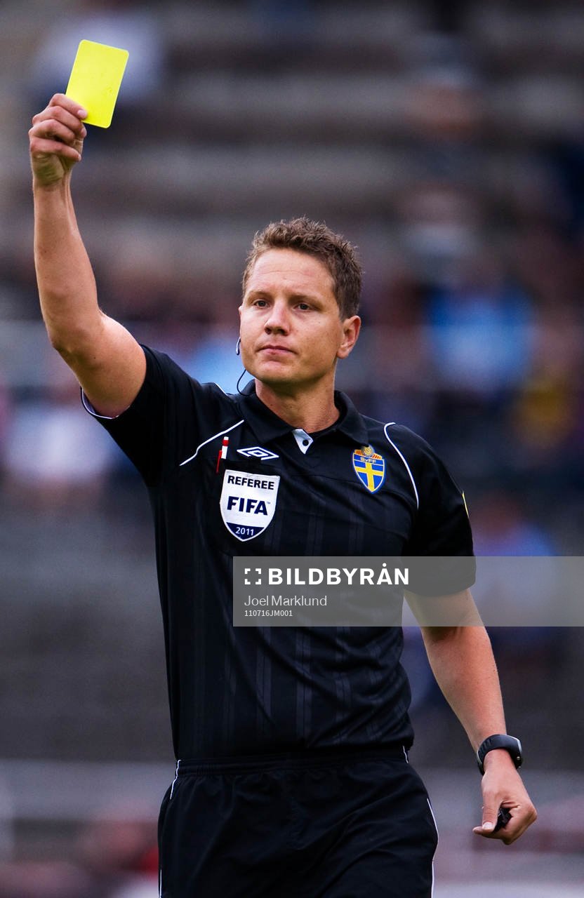 Martin Strömbergsson, domare, delar ut ett gult kort