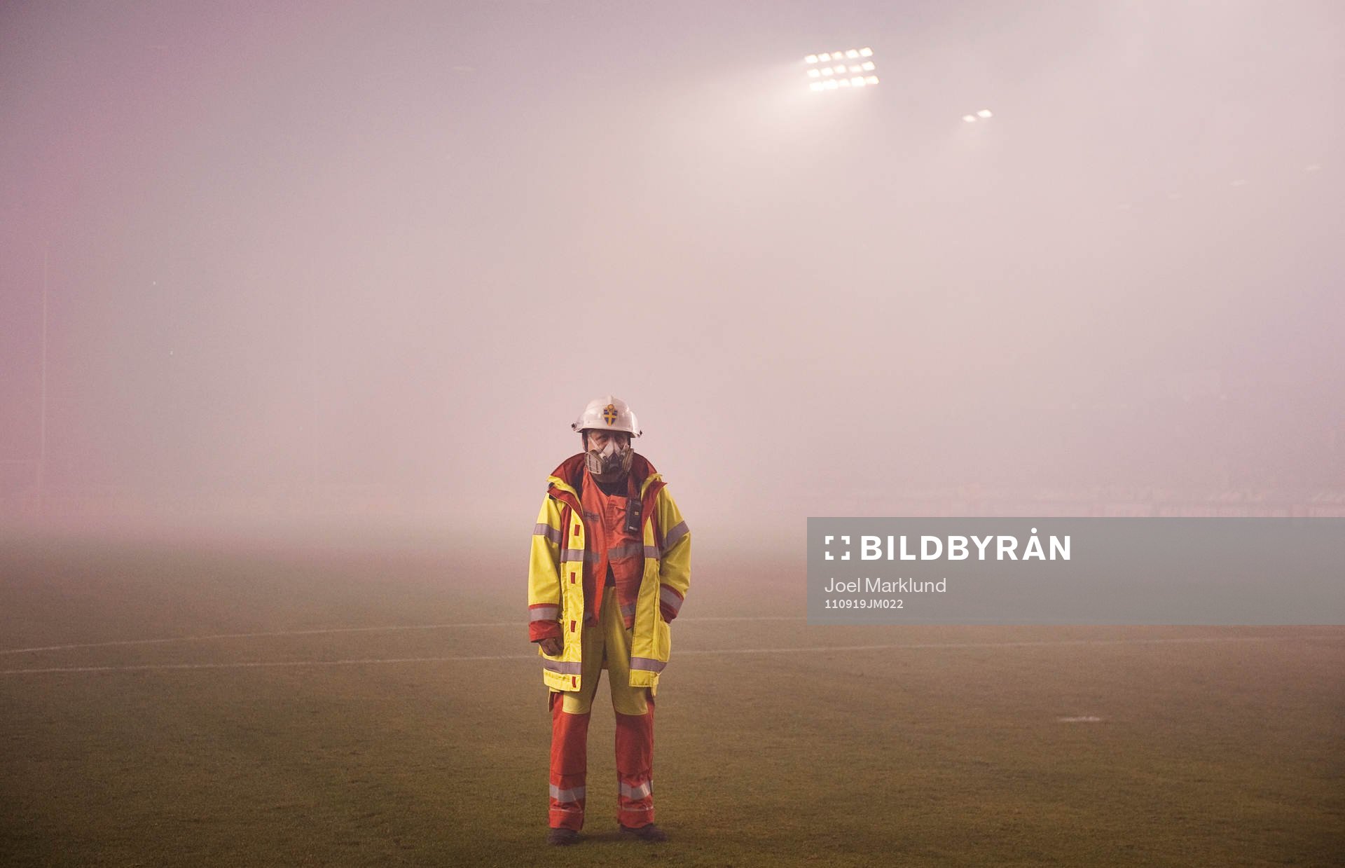En brandman står ute på plan när matchen avbrutits.