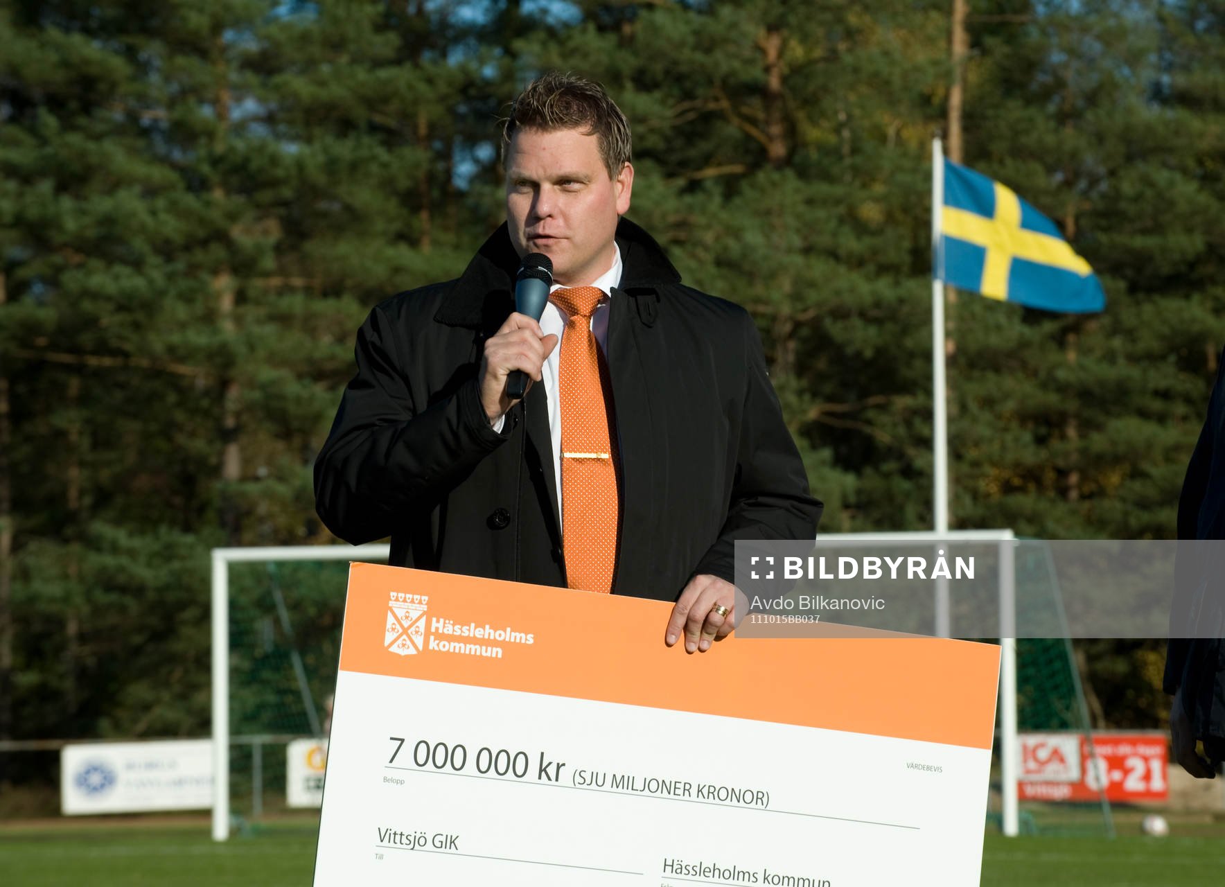 Urban Widman, från Hässleholms kommun lämar en check på