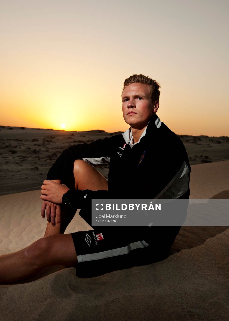 Oscar Hiljemark sitter på sanden när solen går ned i