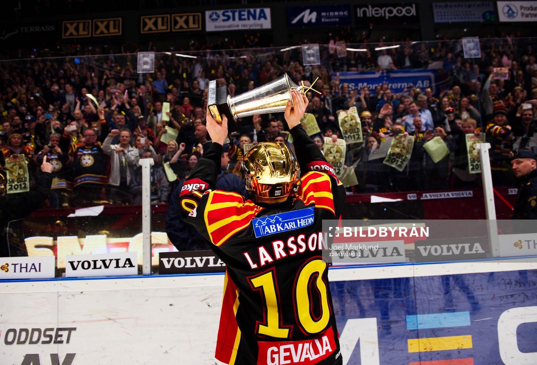 Johan Larsson, Brynäs, håller upp pokalen mot publiken.