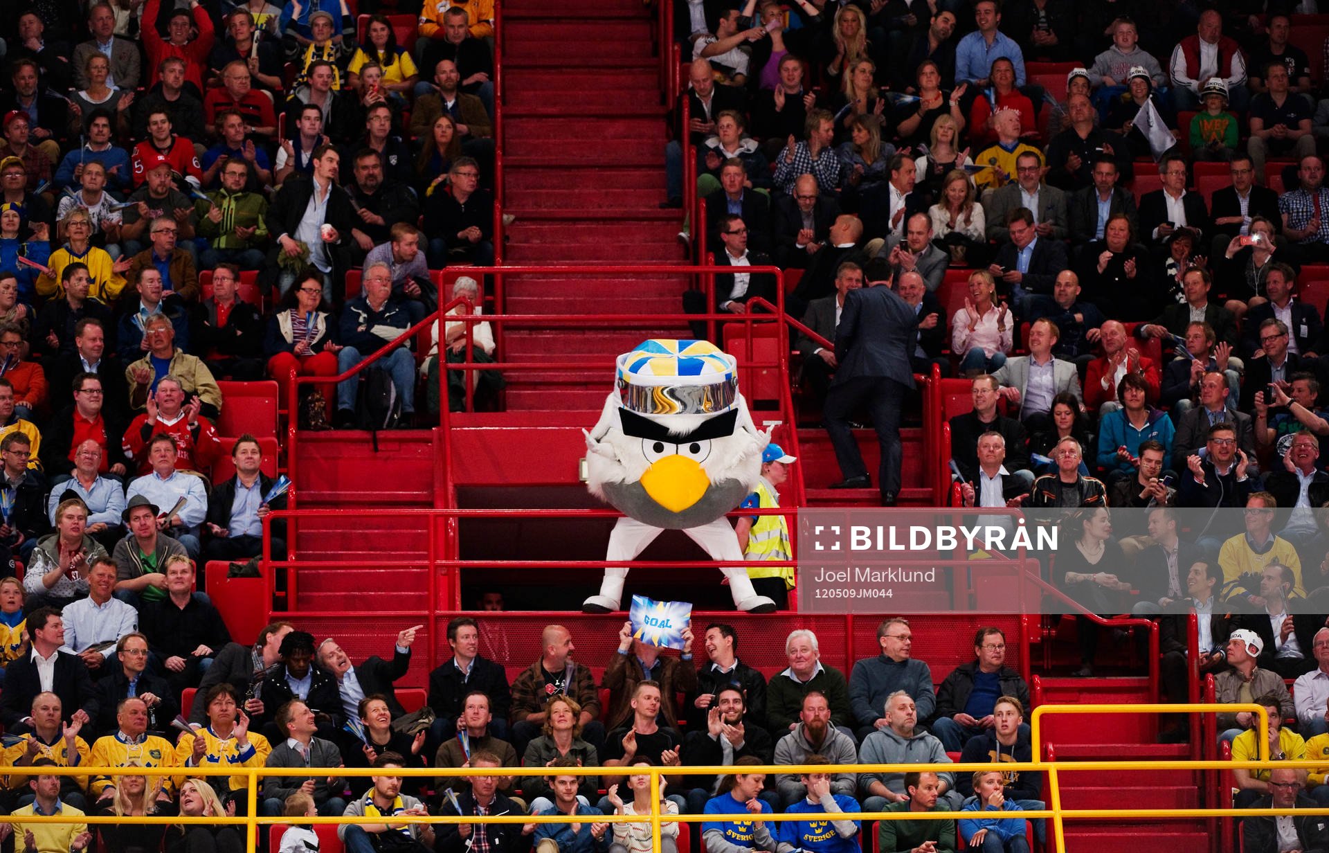Maskoten Hockey Bird eldar på publiken. Maskot,