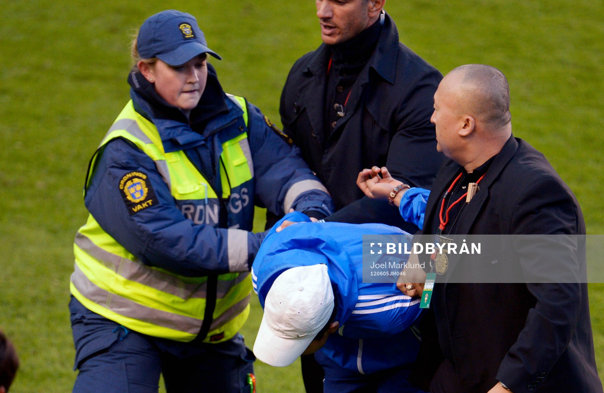 En supporter springer in på planen. Ordningsvakt