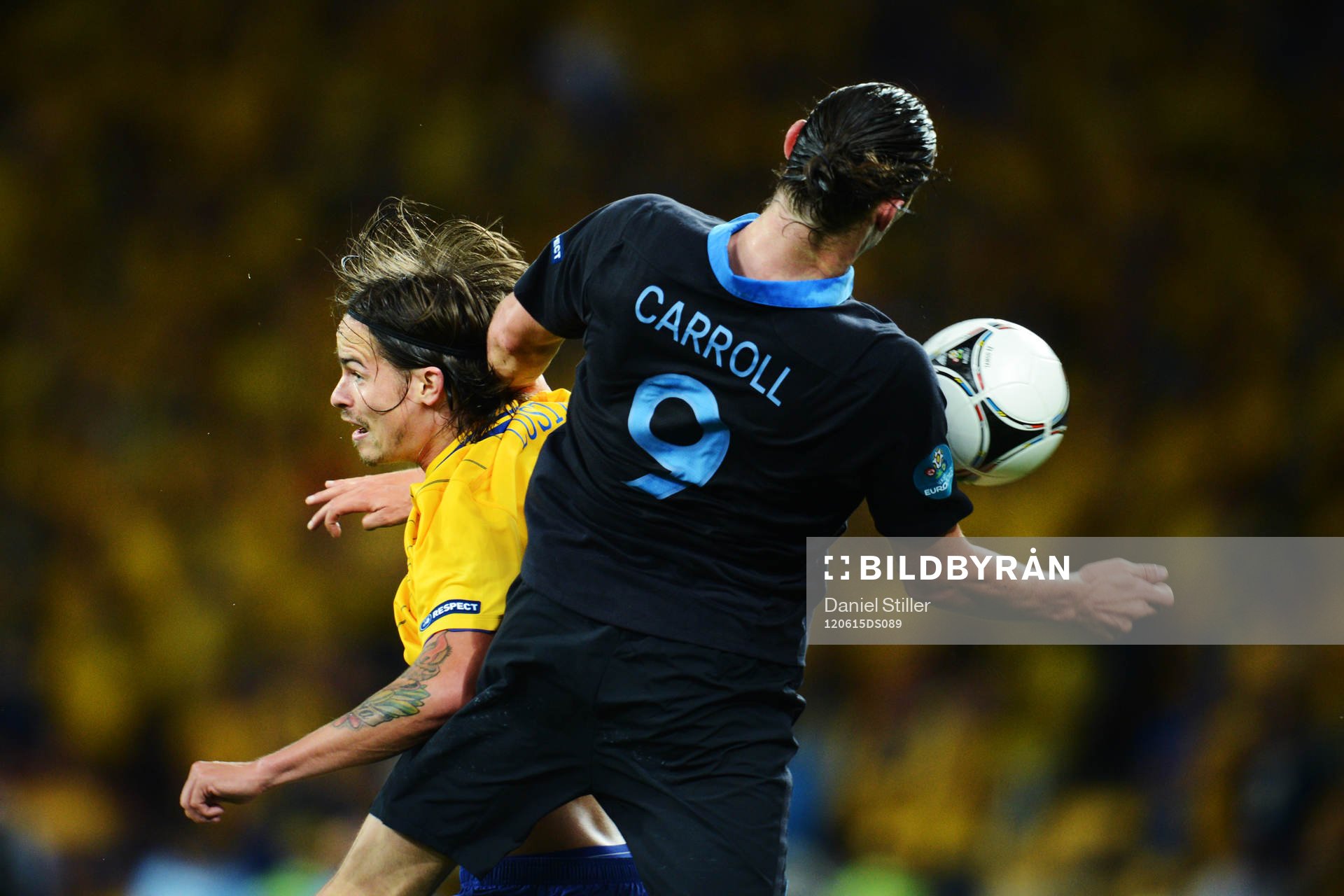 Mikael Lustig, Sverige, i en luftduell med Andy Carroll,