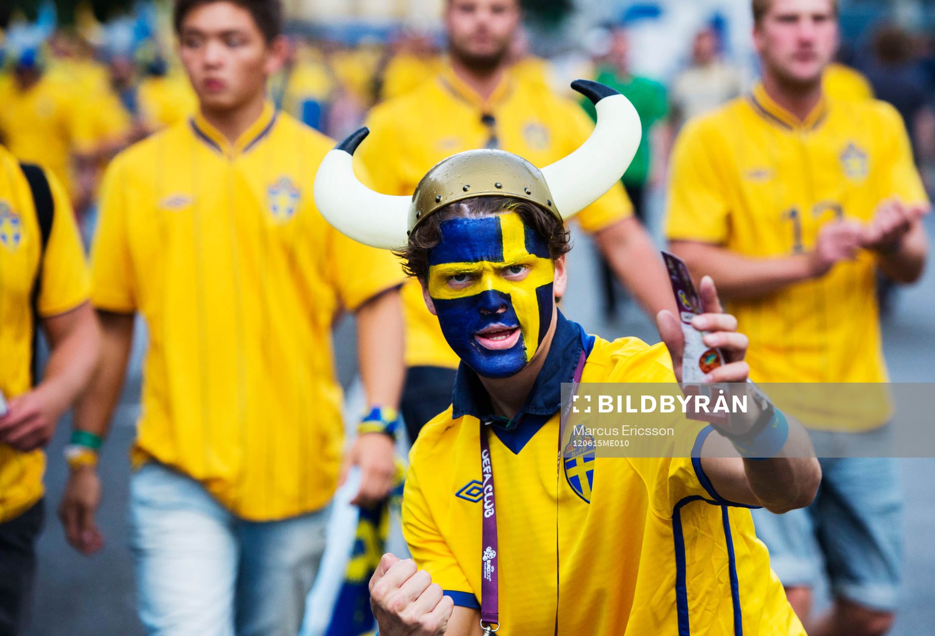 Ett svenskt fan, supporter med vikingahjälm på väg mot