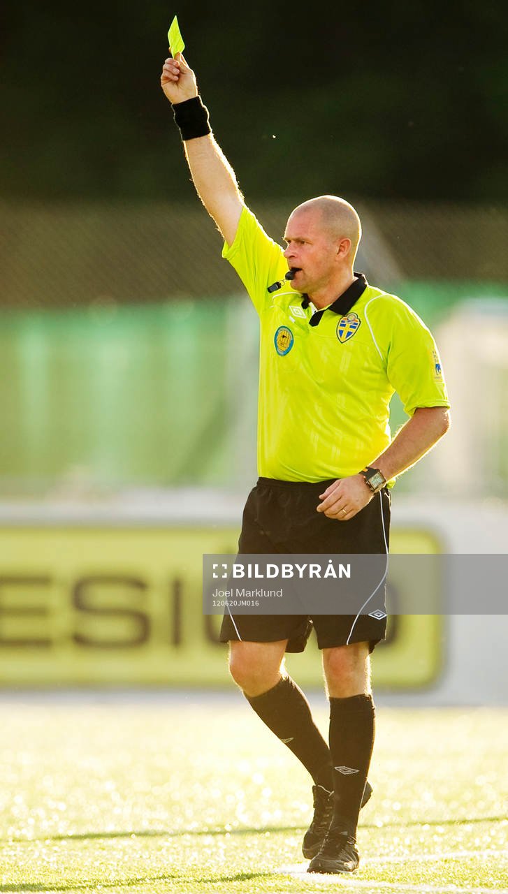 Mattias Nyman, domare, delar ut ett gult kort