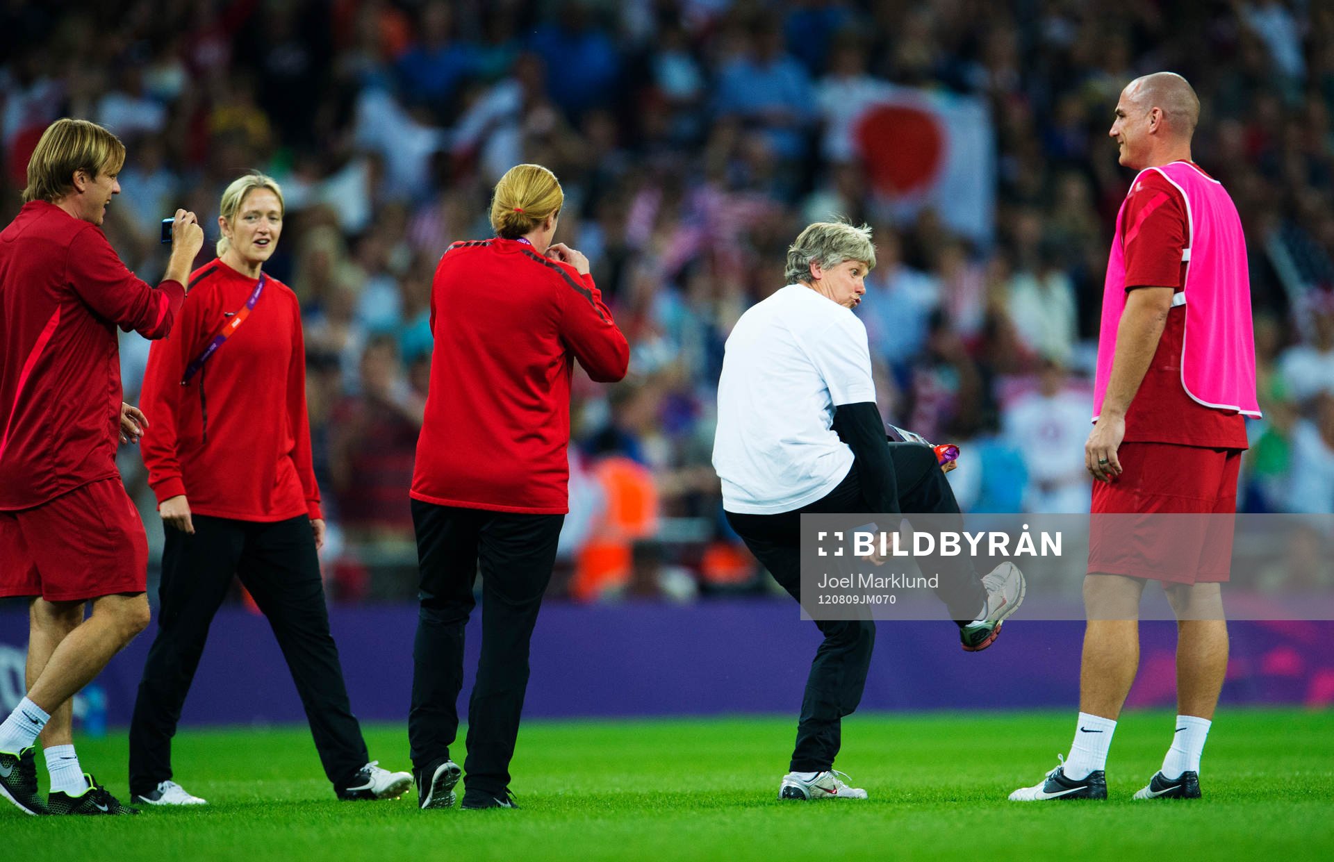 OS 2012, Fotboll, dam, final, USA - Japan: Tony Gustavsson, assisterande tränare, fotograferar Pia Sundhage, tränare, USA, som dansar på planen.