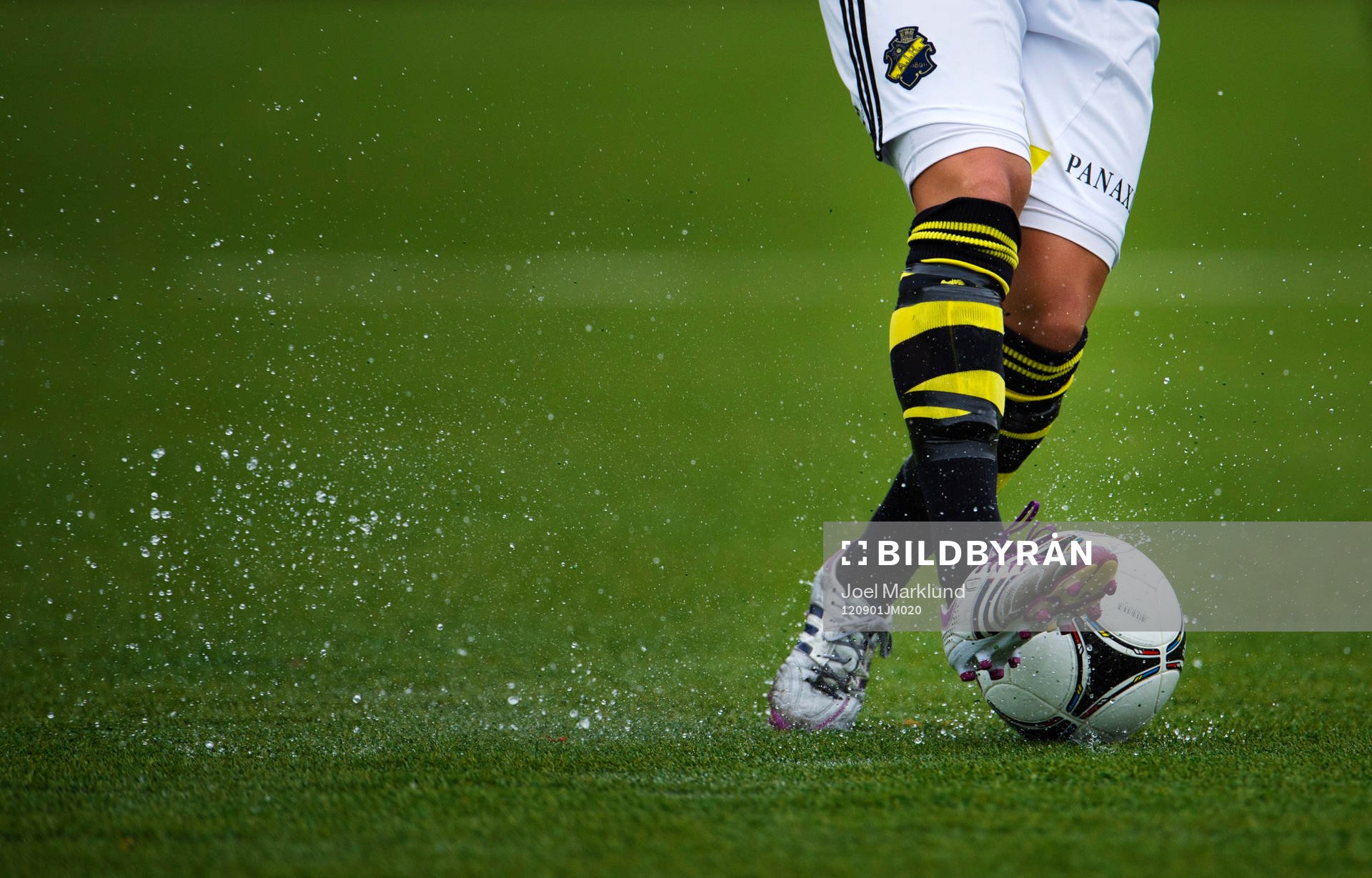 En AIK-spelare kontrollerar bollen på