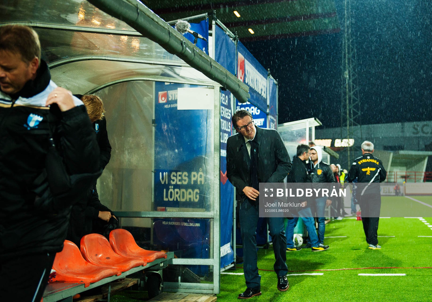 Rikard Norling, tränare Malmö FF, söker skydd för regnet