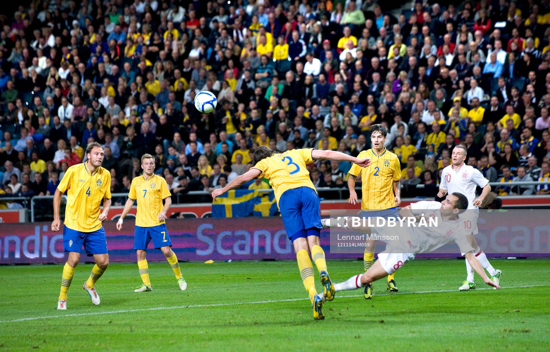 Jonas Olsson, Sverige, nickar undan framför Leon Osman,