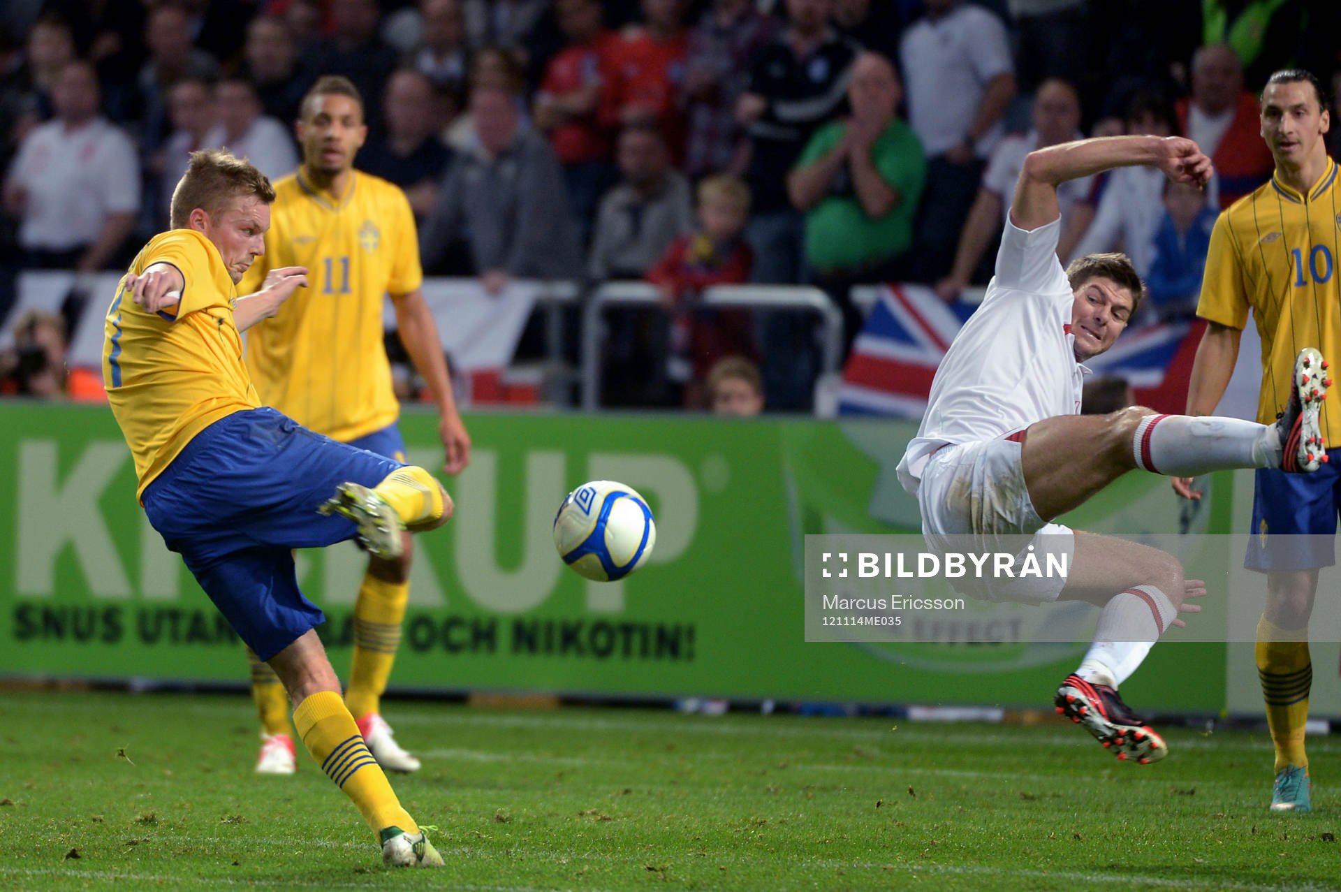 Sebastian Larsson, Sverige, testar skott. Steven Gerrard,