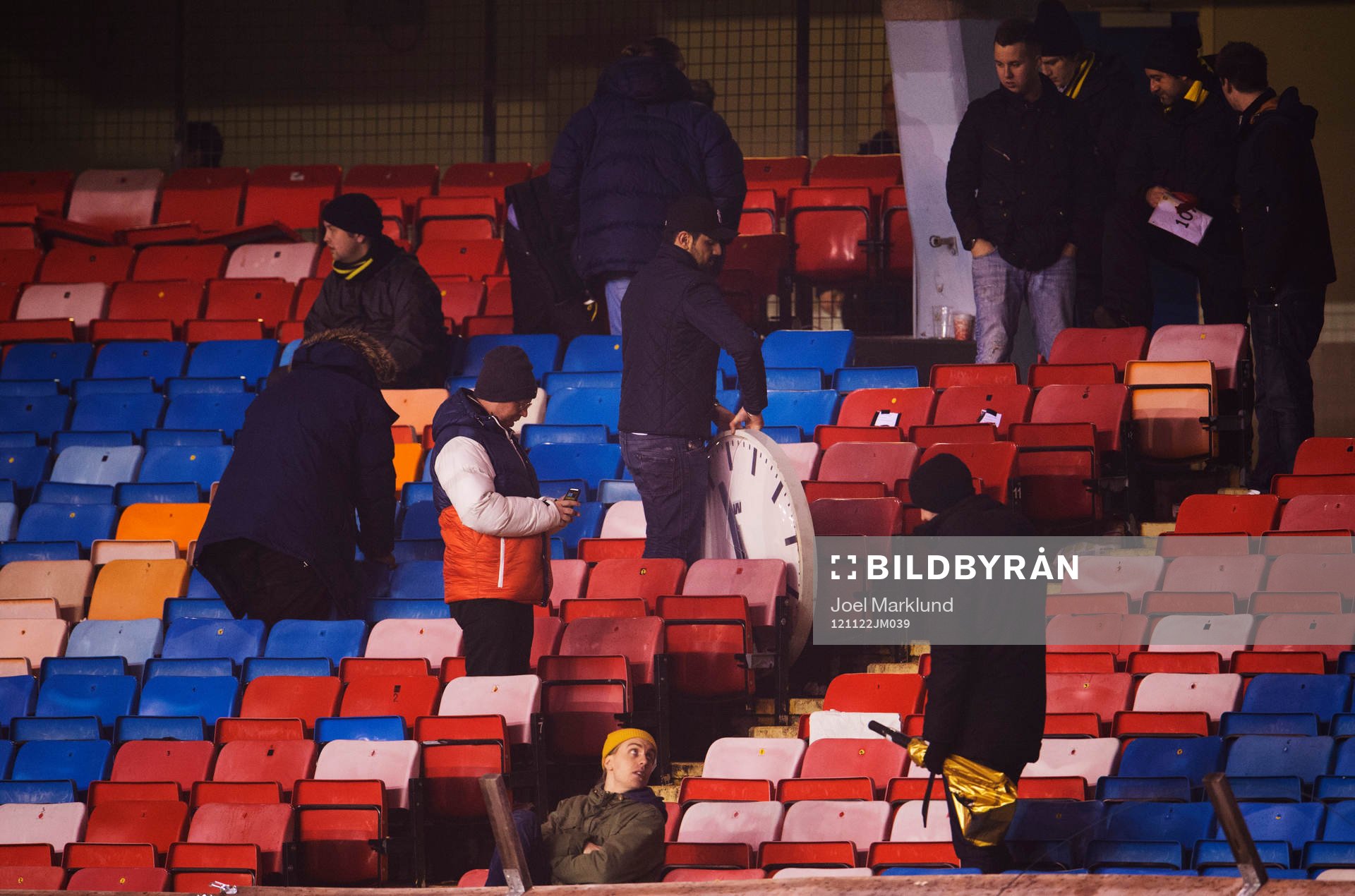 Folk plundrar Råsunda Arena. Klockan på östra sidan